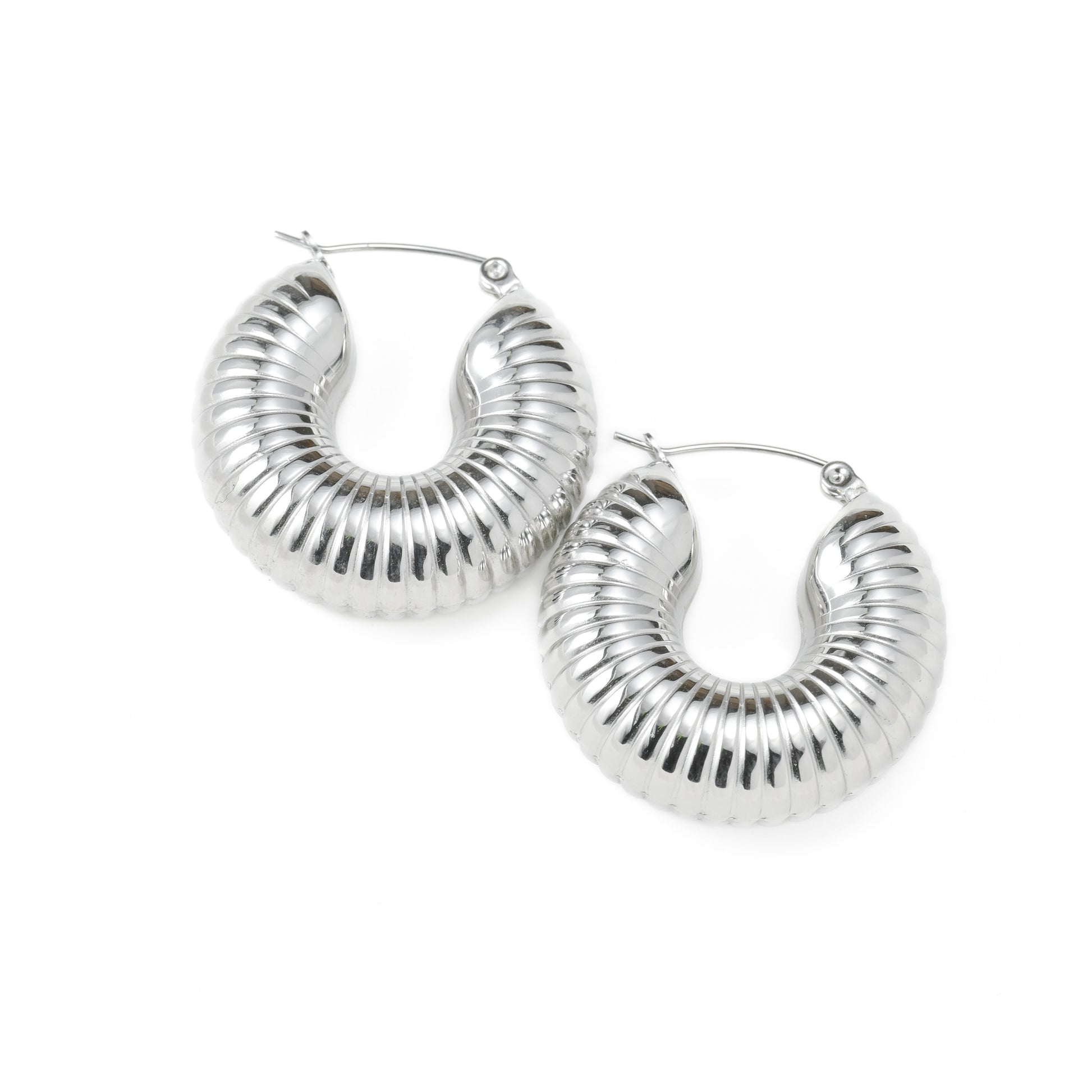 Thick textured silver hoop earrings on a white background