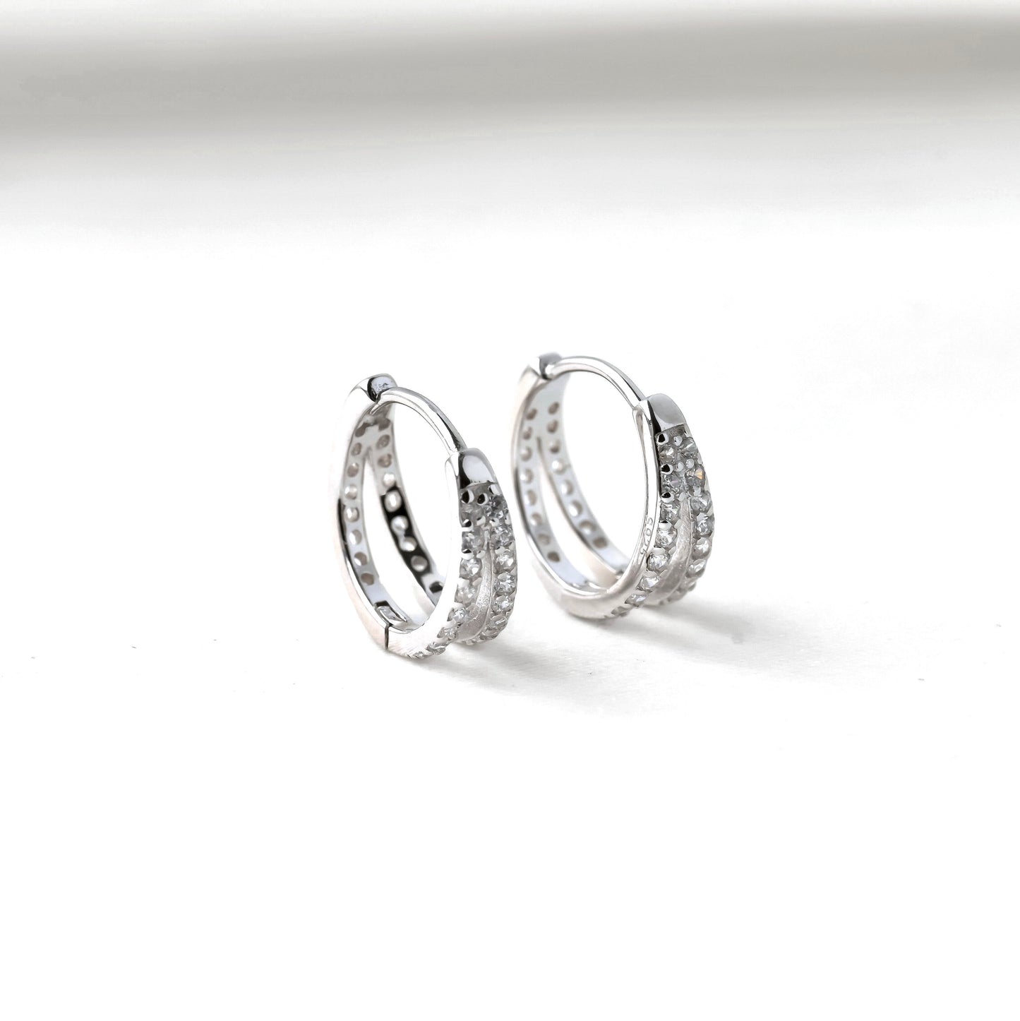 Pair of silver CZ hoop earrings on a white background