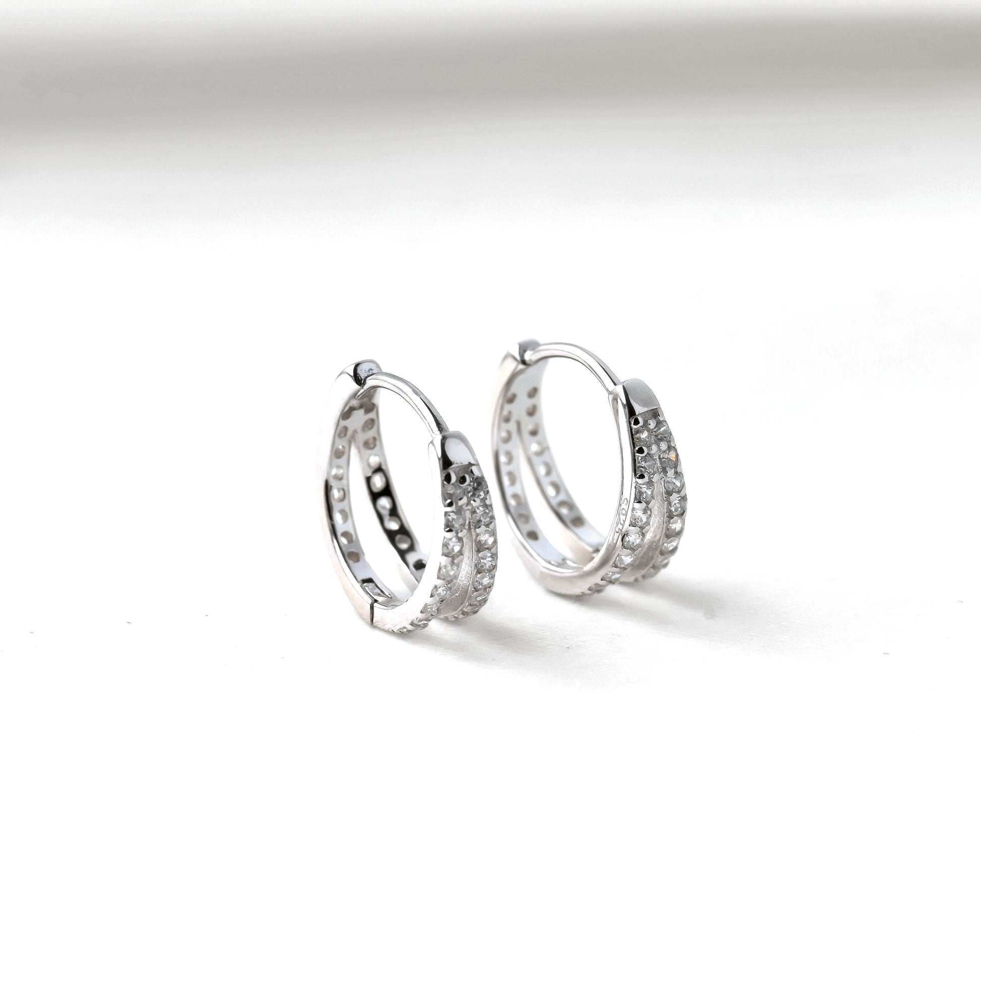 Pair of silver CZ hoop earrings on a white background