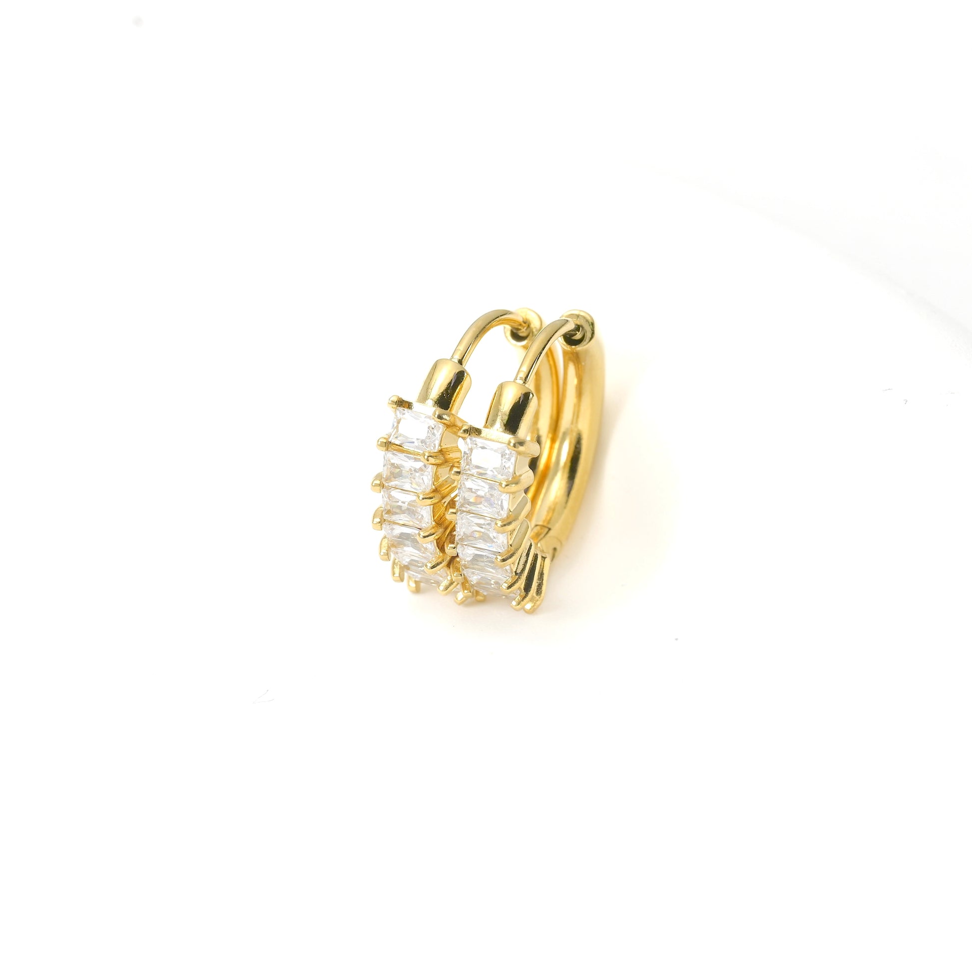 Gold hoop earring with clear gemstones on a white background