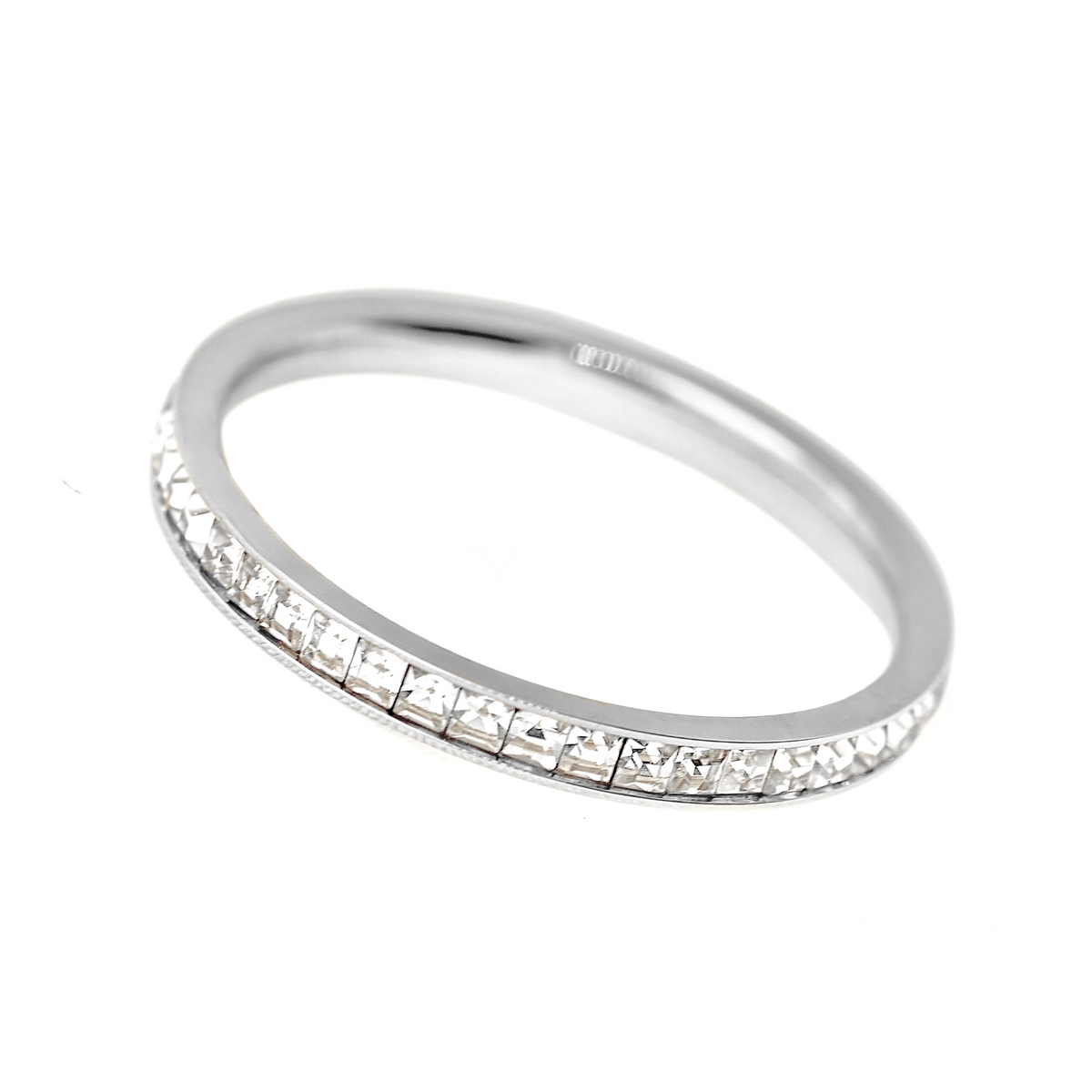 A silver eternity ring featuring a continuous row of small, clear rectangular baguette-cut gemstones set along the band, shown on a plain white background.