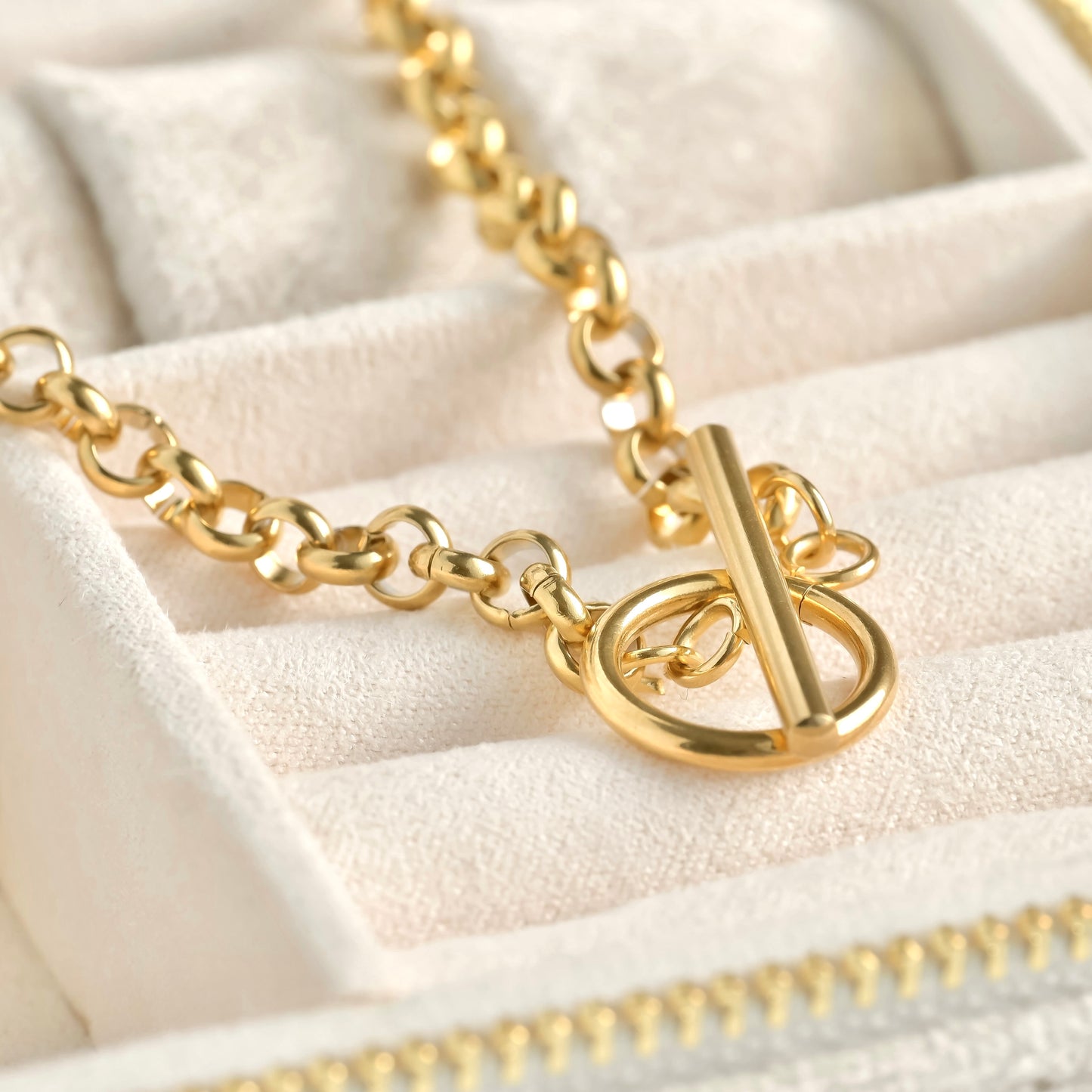 Close up of toggle clasp on the rolo chain on a beige jewelry display
