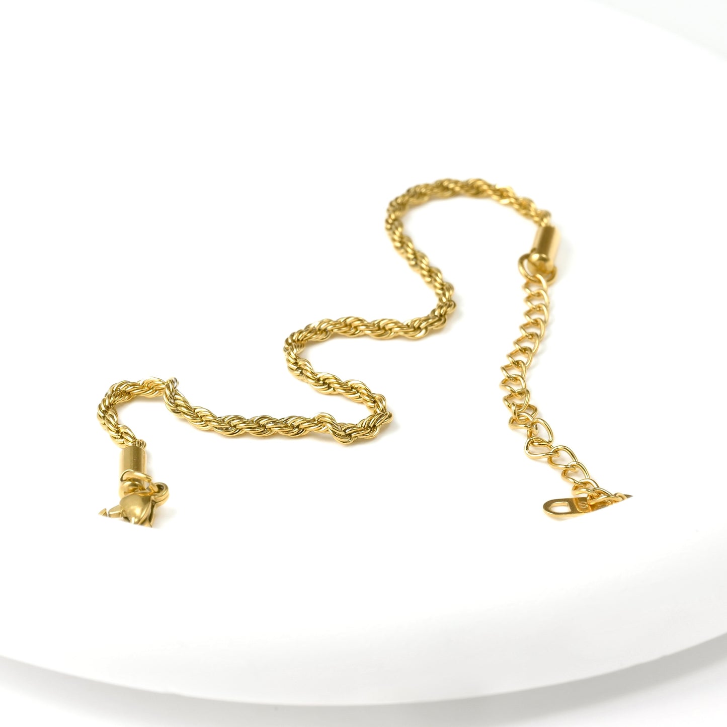 Gold twisted chain bracelet with a lobster clasp and extender chain on a white background