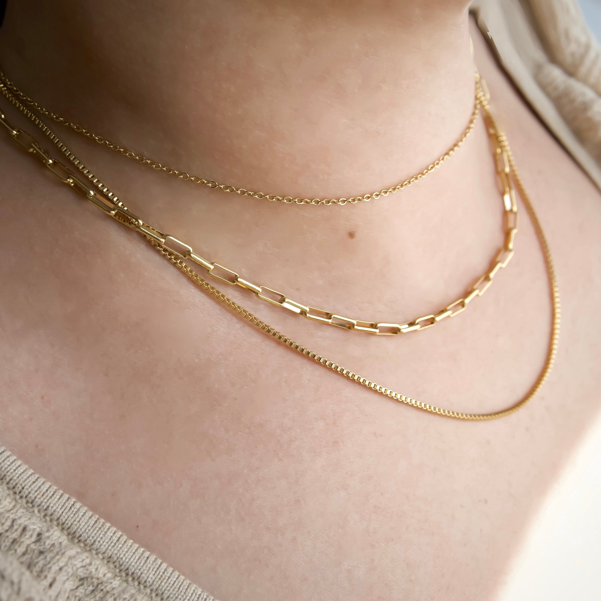 Side view of 3 in 1 gold chain necklace set on a person's neck
