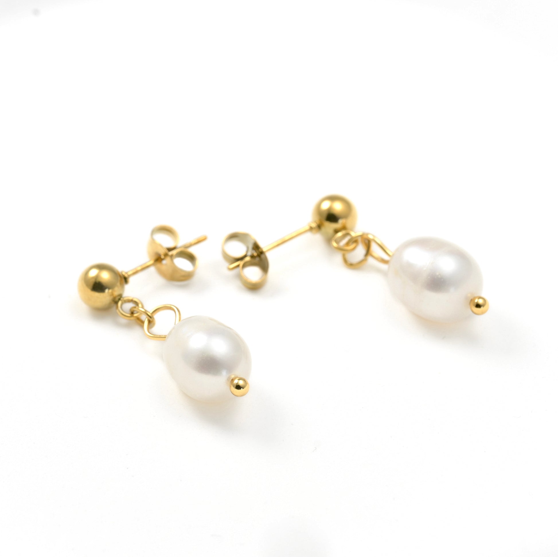 Dainty Pearl drop earrings with gold accents on a white background