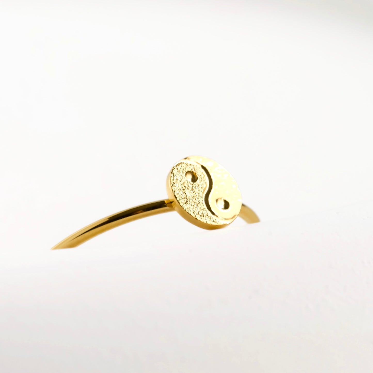 Close-up view of the yin and yang charm on the ring on a light gray background