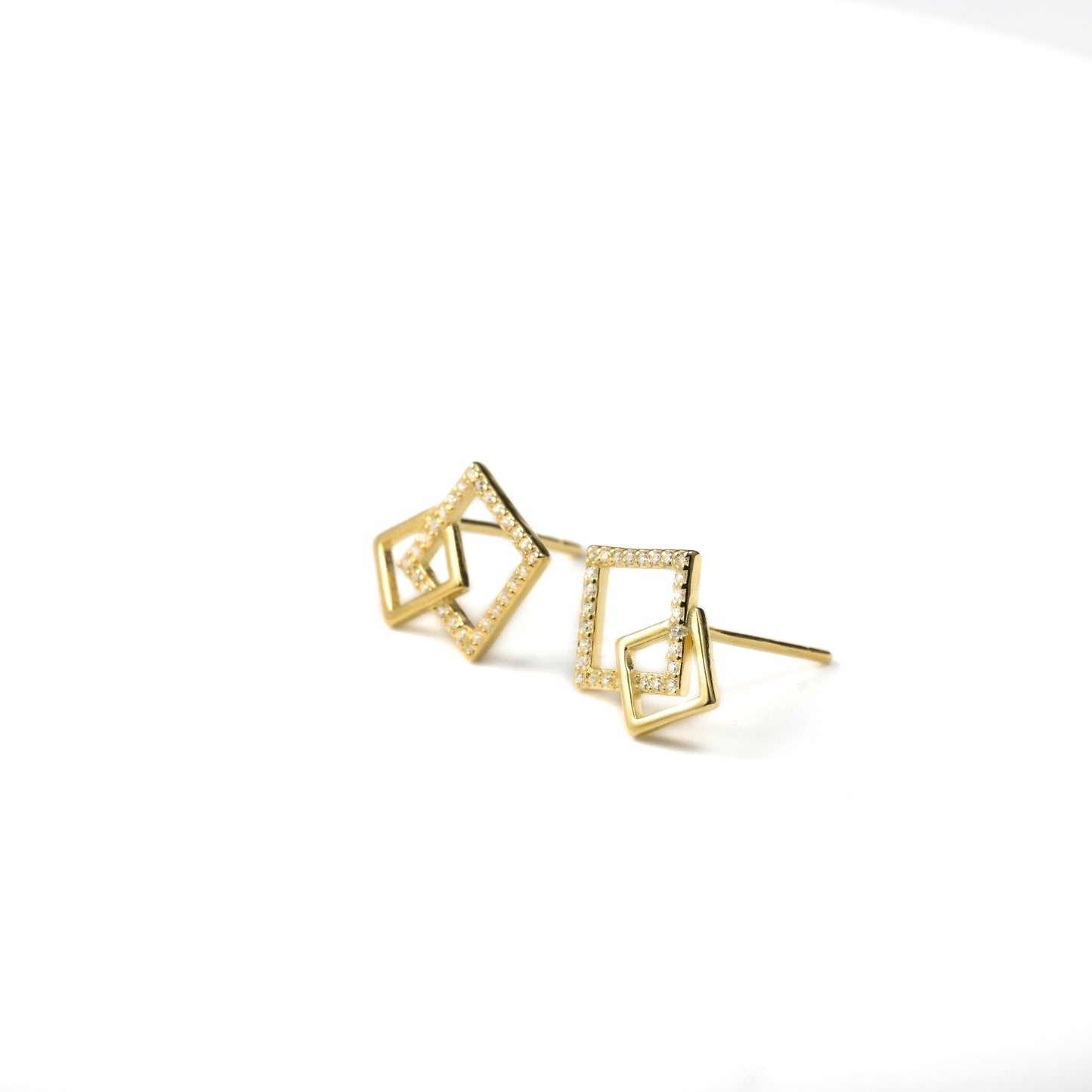 Gold geometric earrings on a white background