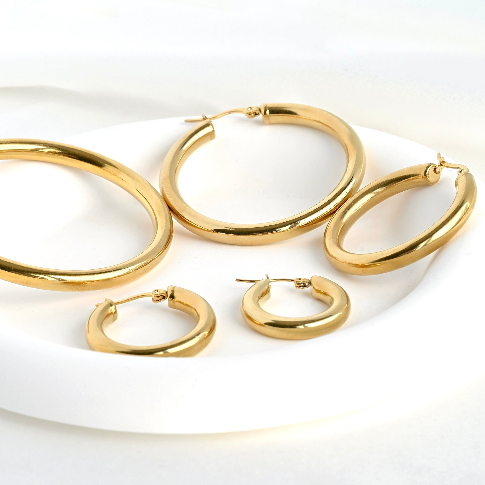 Set of  thick statement earrings on a white plate