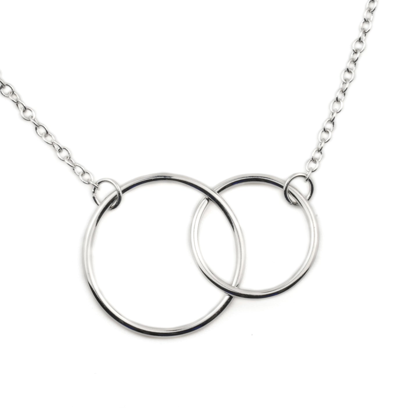 Close-up of silver necklace with interlocking rings on a white background