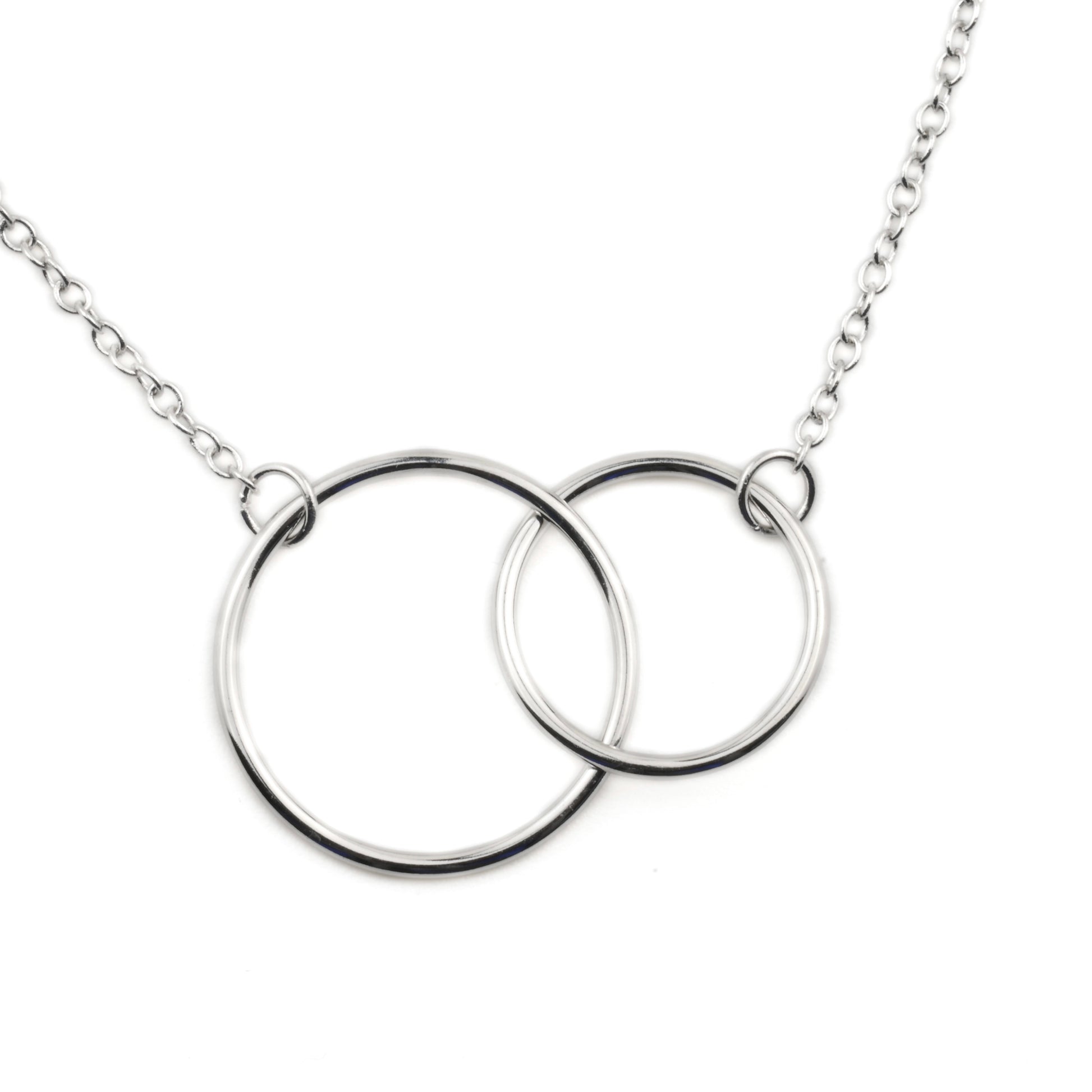 Close-up of silver necklace with interlocking rings on a white background
