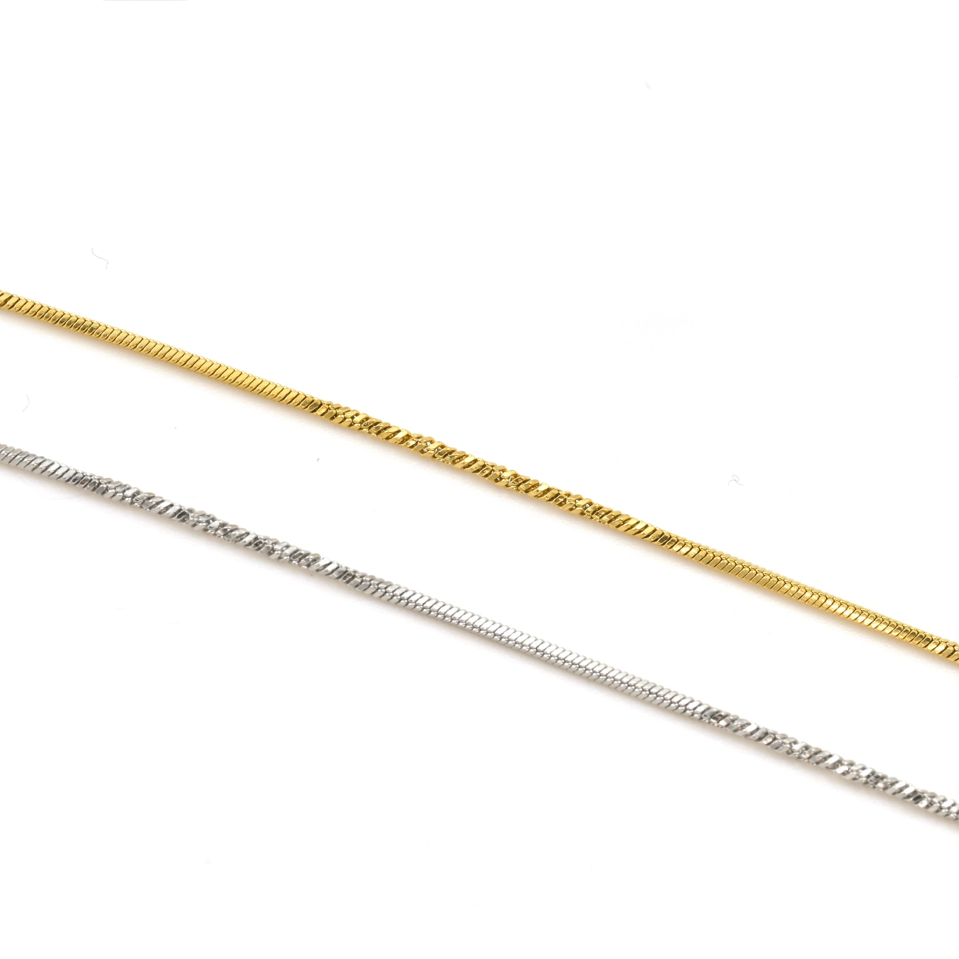 Two gold and silver skinny snake necklaces on a white background