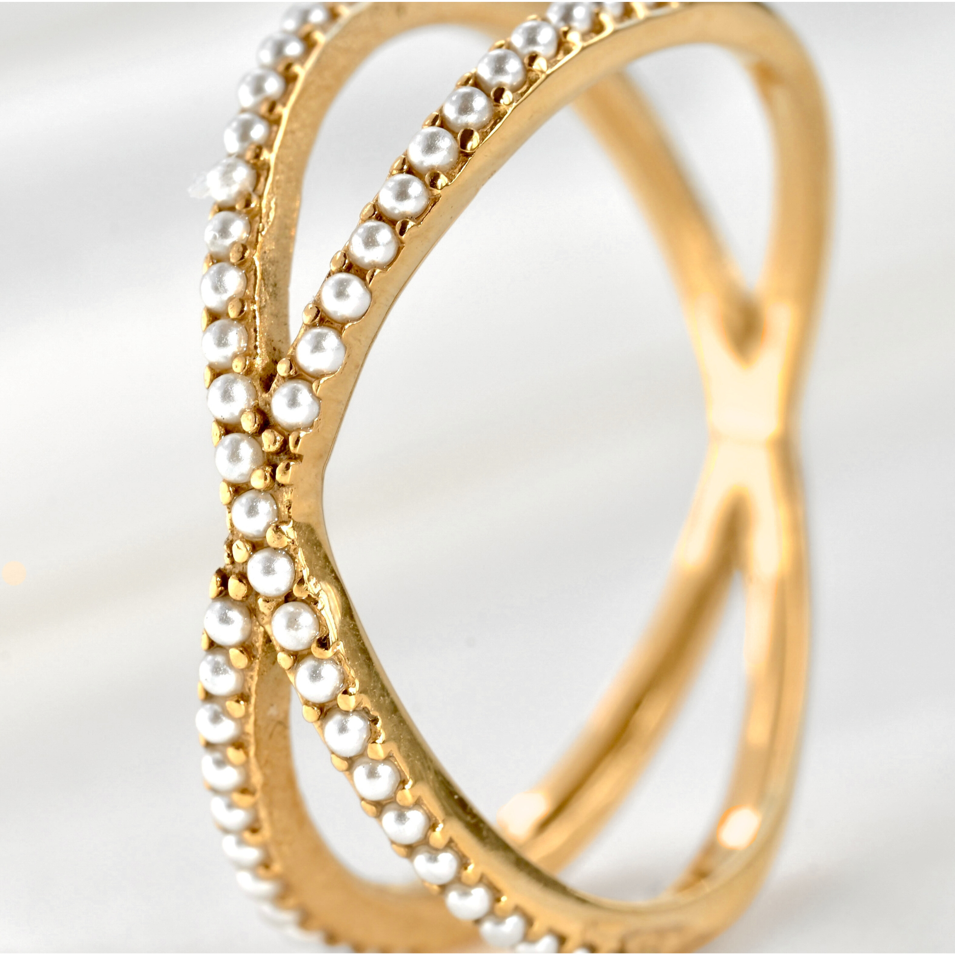 Close-up view of tiny pearls embedded on the front side of the criss cross ring