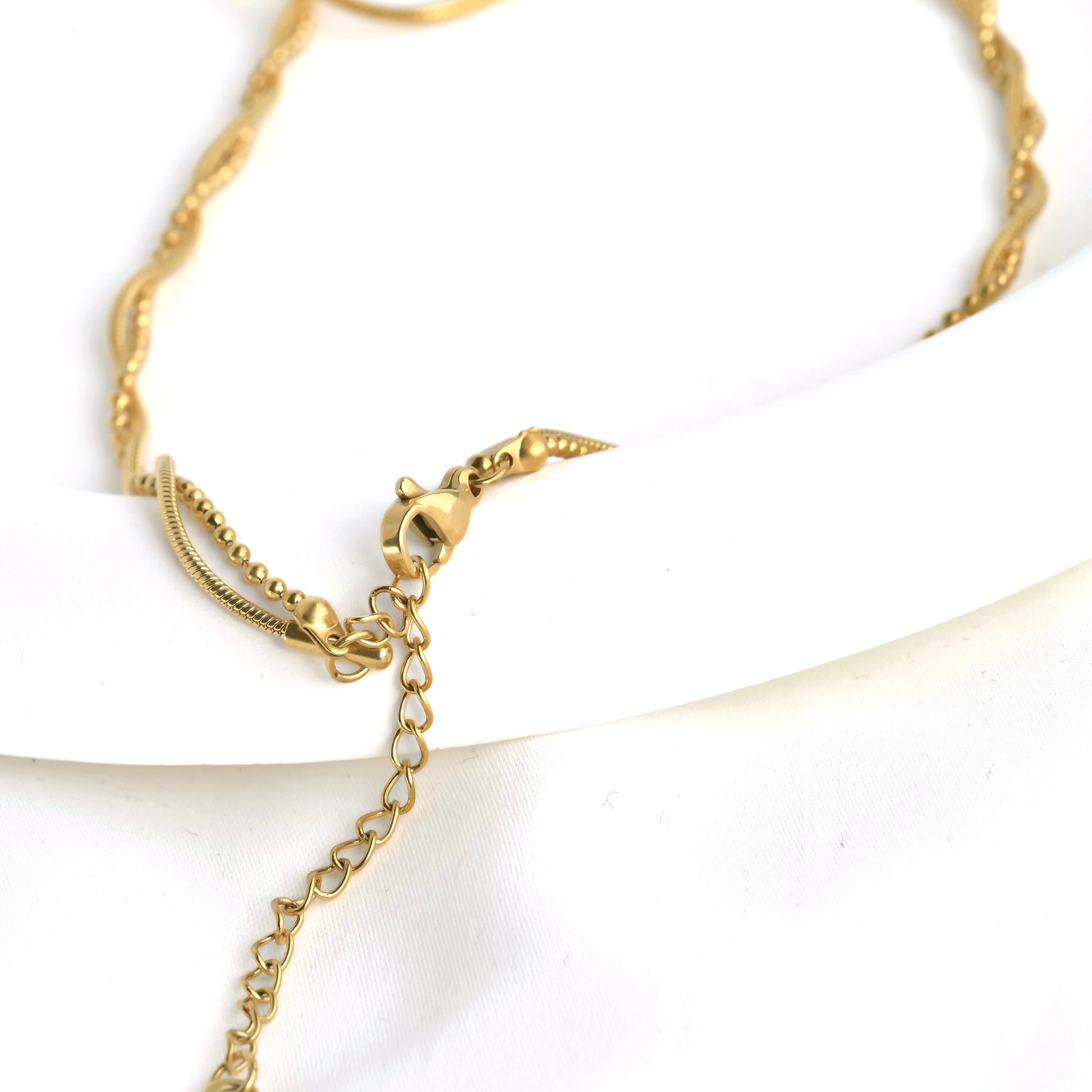 Close up of necklace's clasp area where the ball and snake chain linked together and secured with a lobster claw clasp and extender chain.