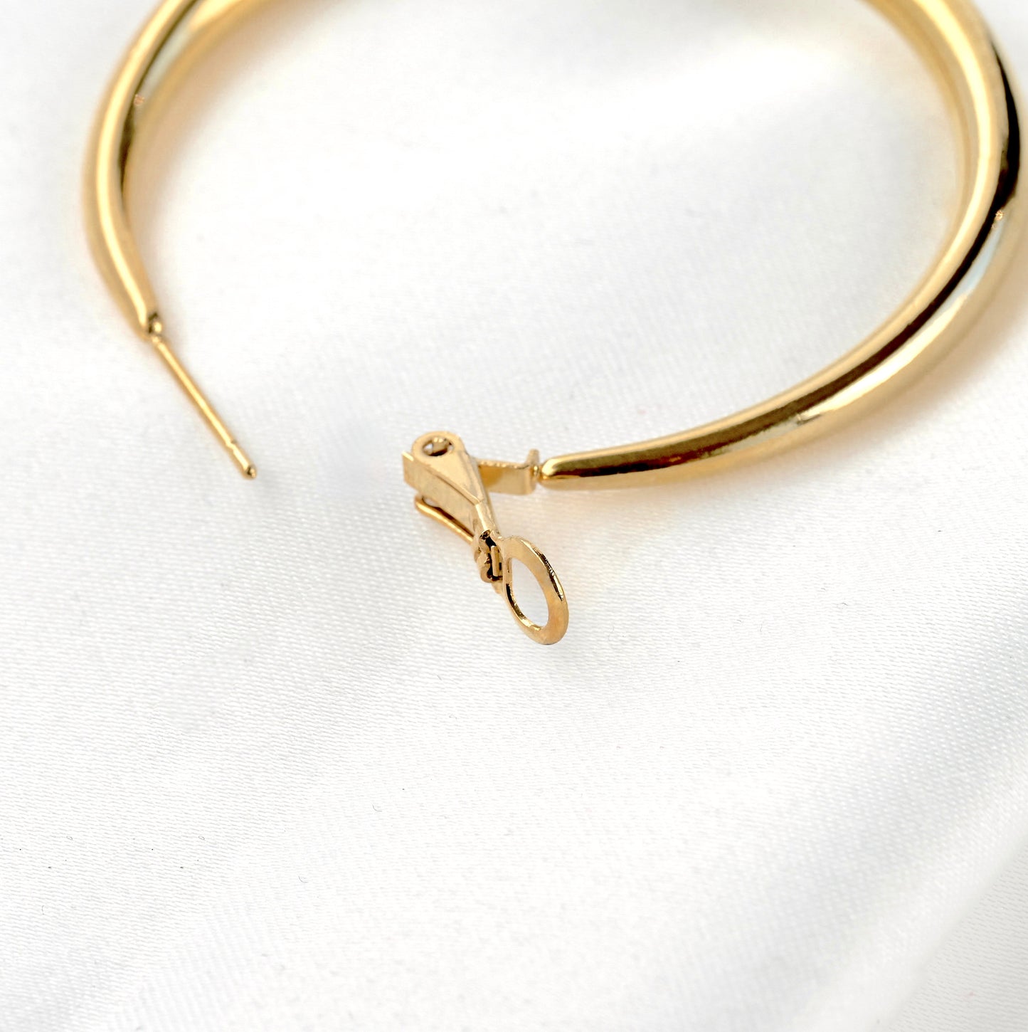 Close-up view of the lever back closure of the hoop earrings