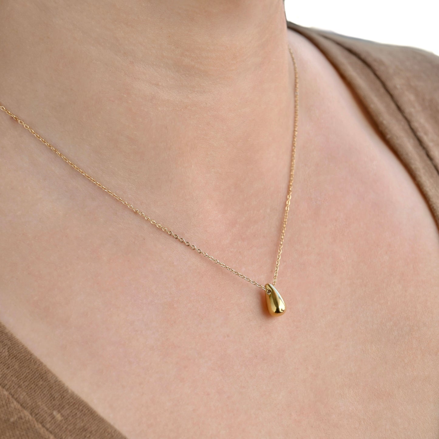 angled view of the person wearing gold necklace