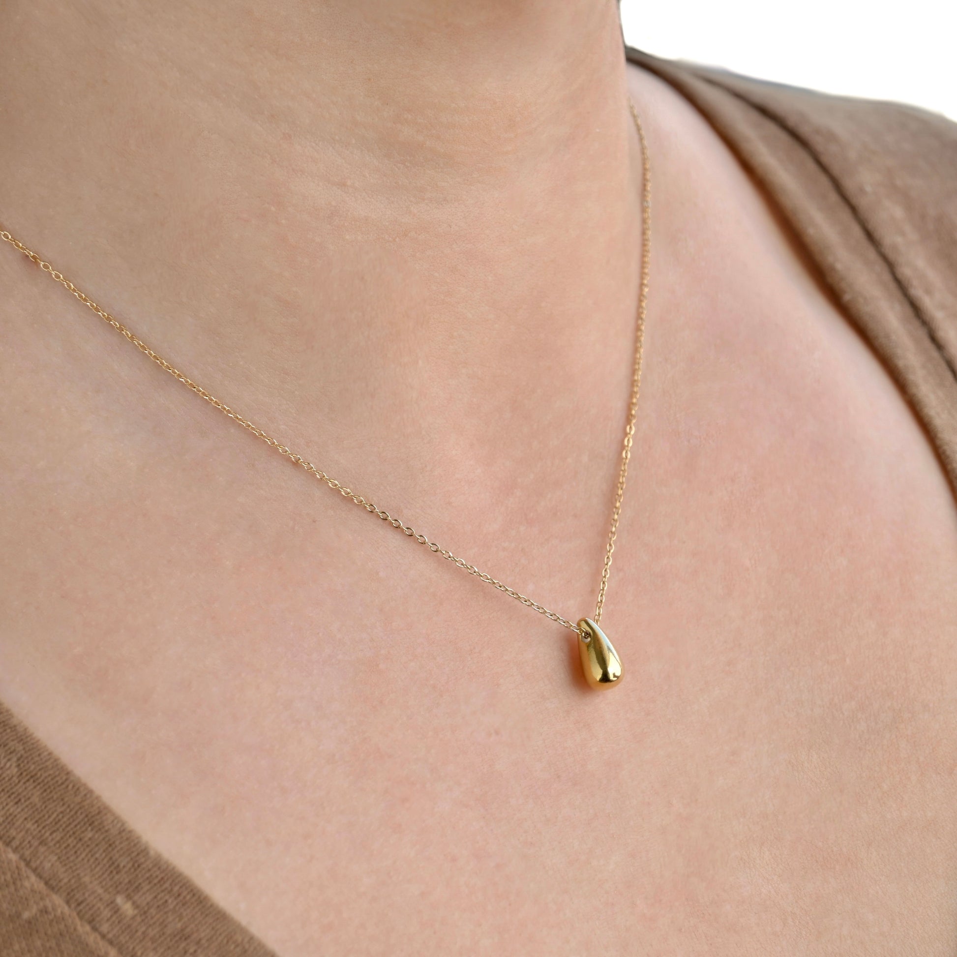 angled view of the person wearing gold necklace