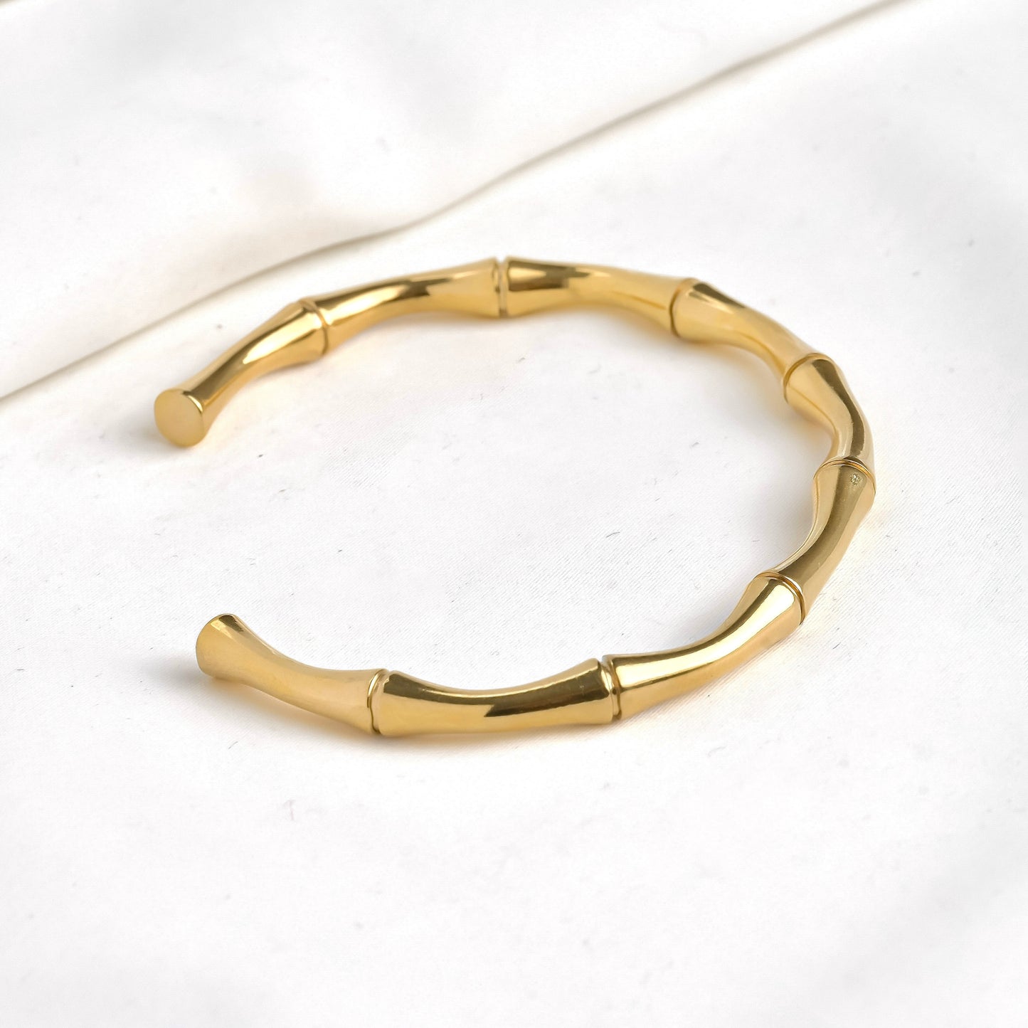 Gold bamboo cuff bracelet on a white background