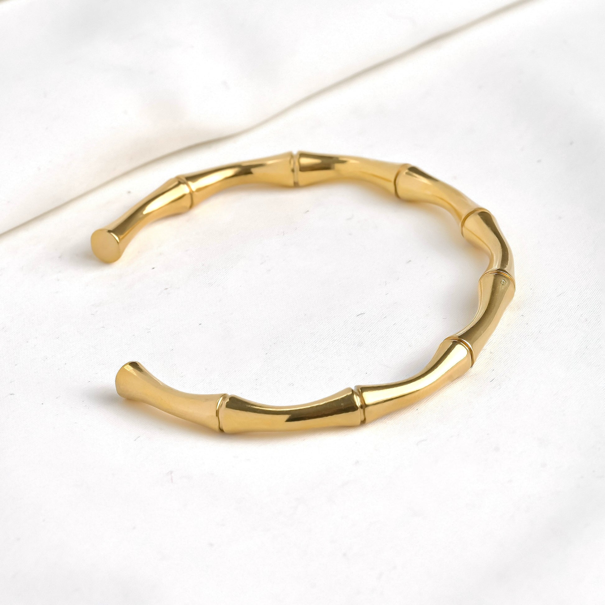 Gold bamboo cuff bracelet on a white background