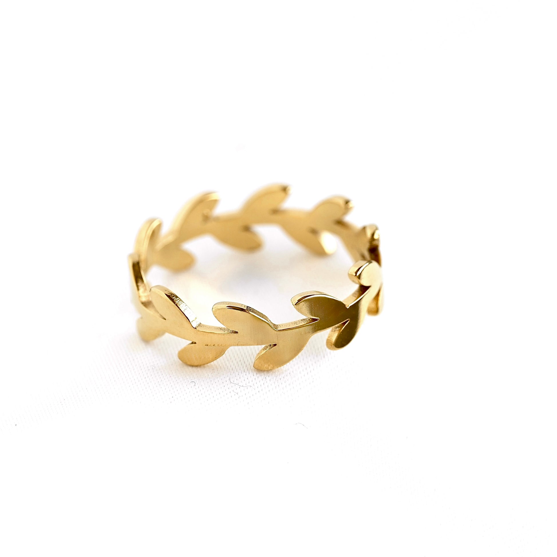 A gold leaf-patterned band ring on a clean white background.