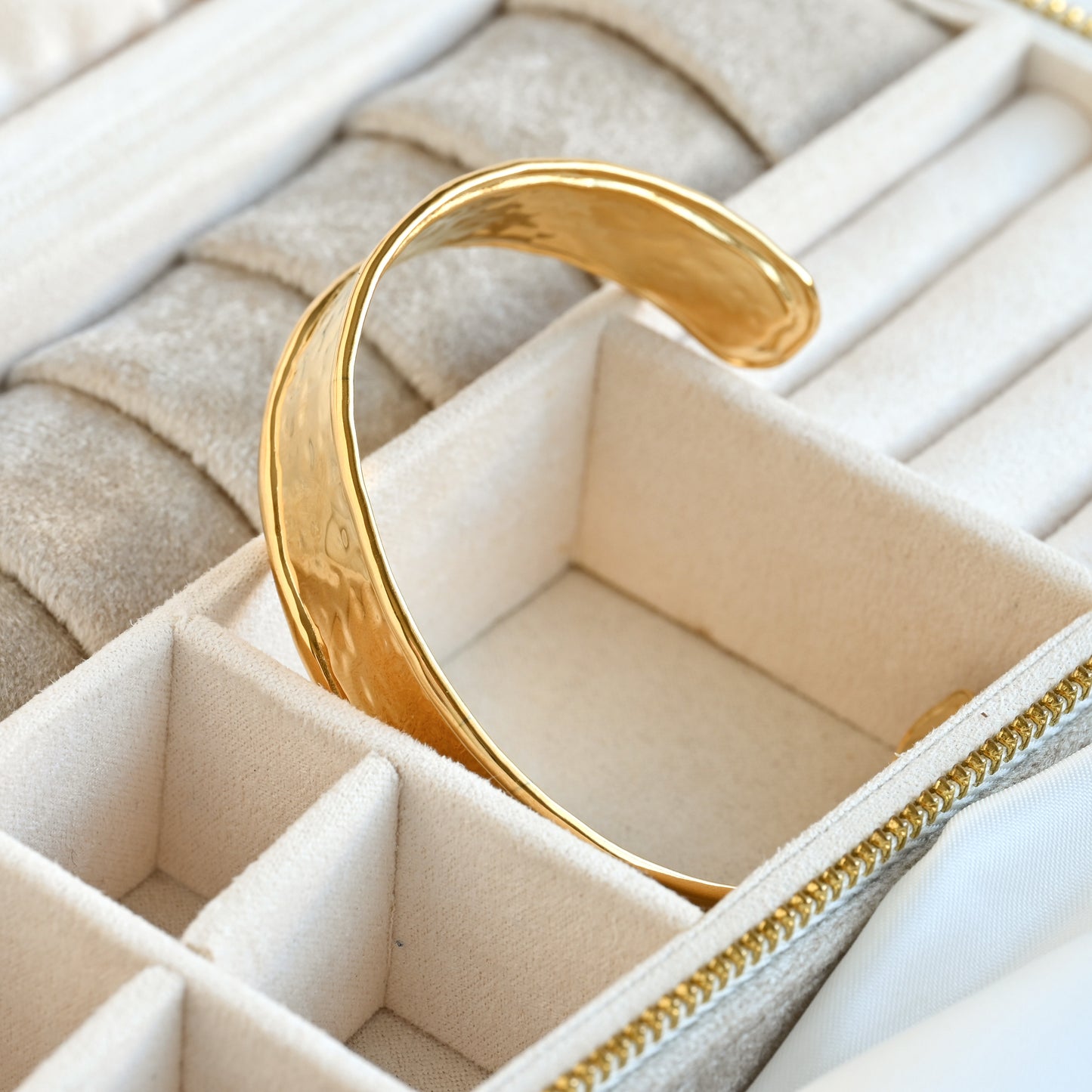 Gold  cuff bracelet in a jewelry box with a beige interior