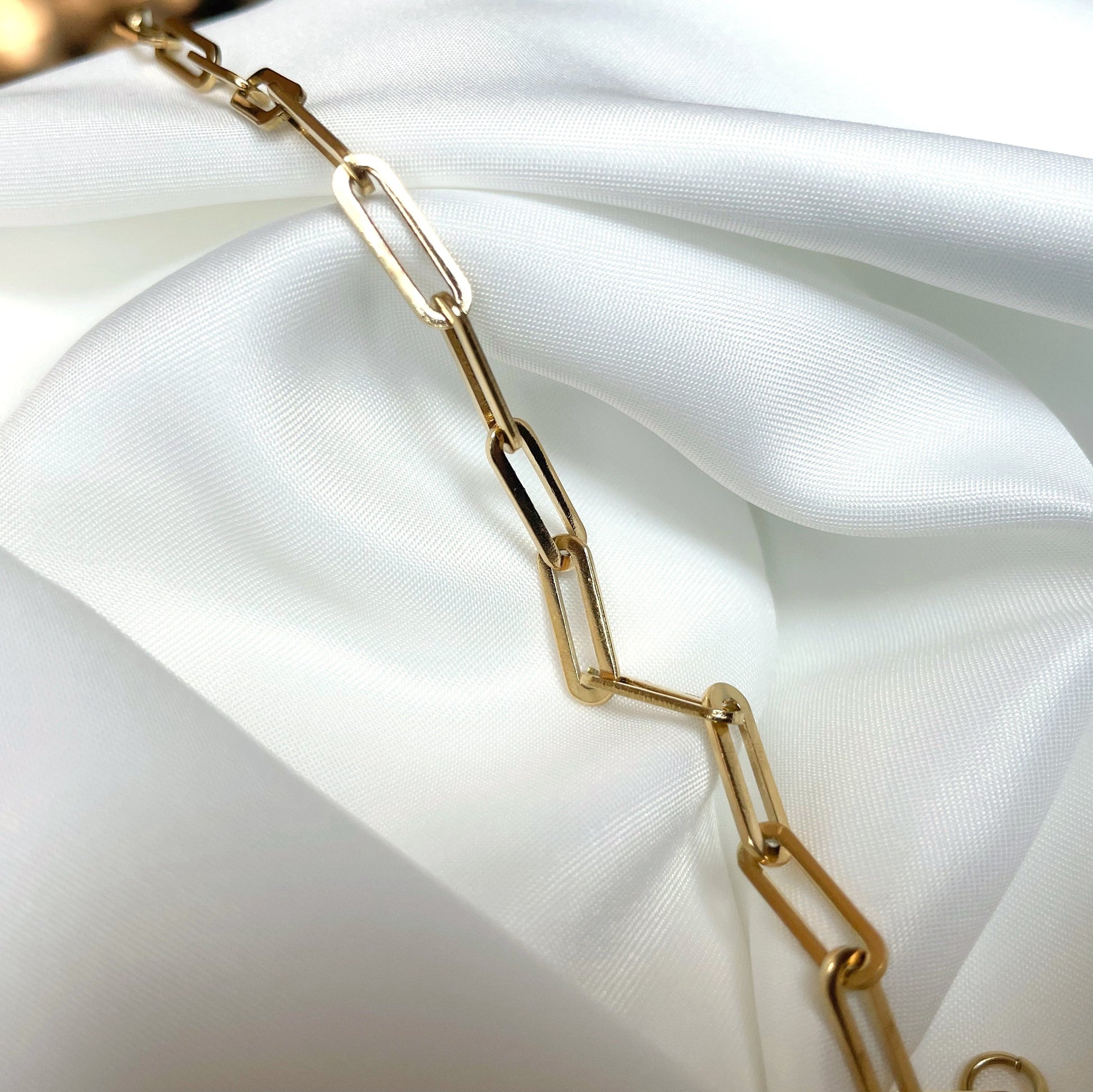 Gold chain on a white fabric background