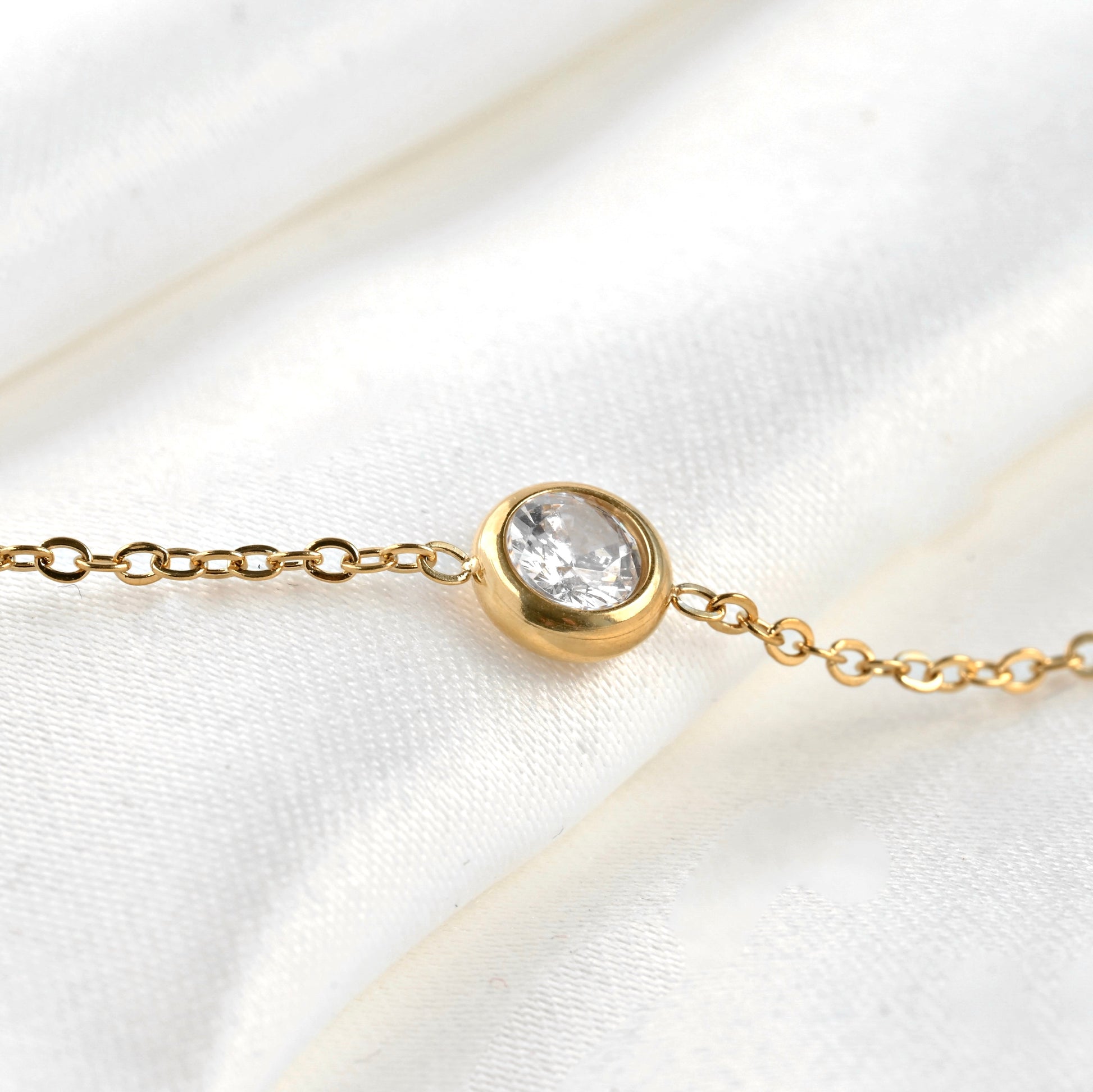 Close up view of one of the crystals in a bezel setting stationed along a delicate cable chain