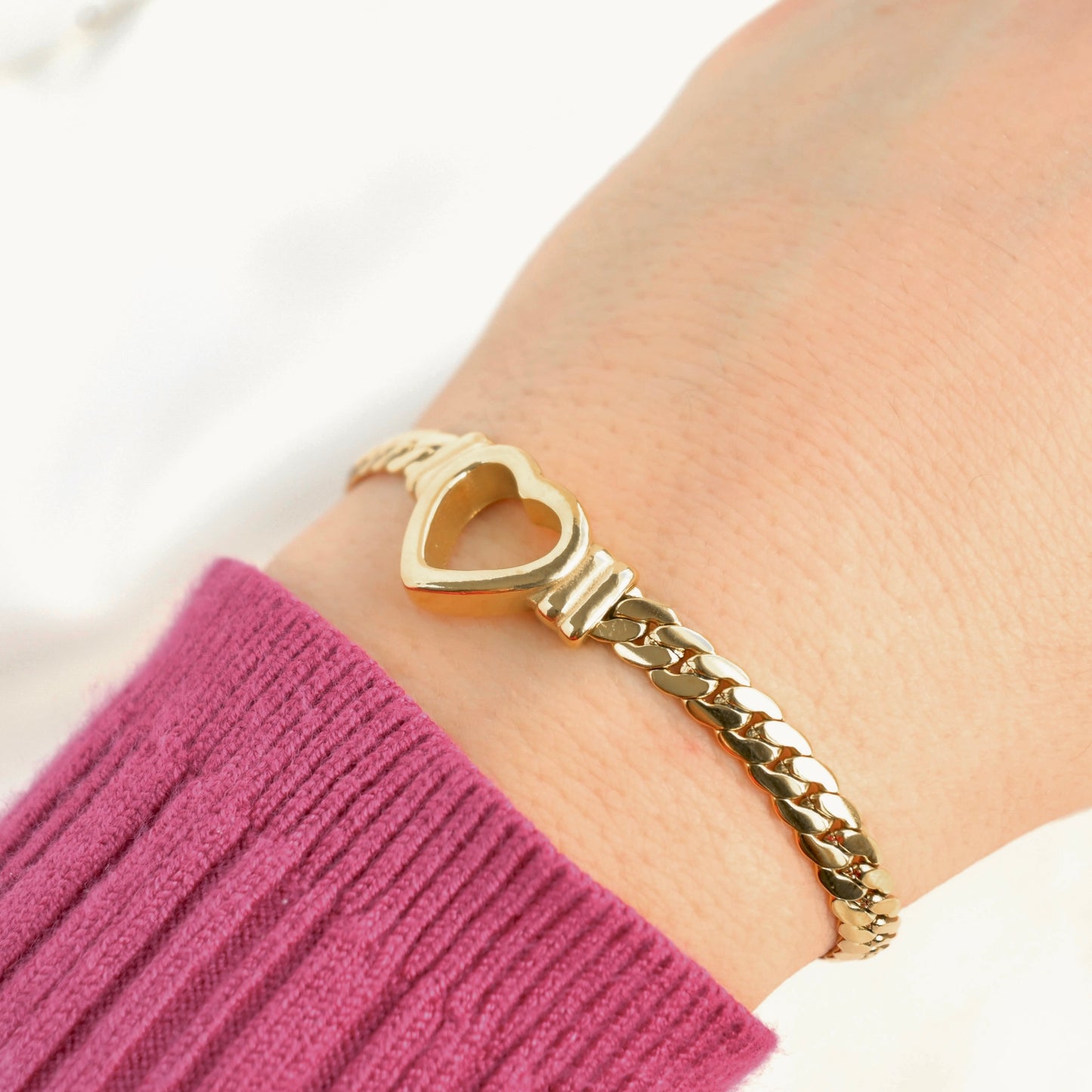 thick heart bracelet on. a person's wrist