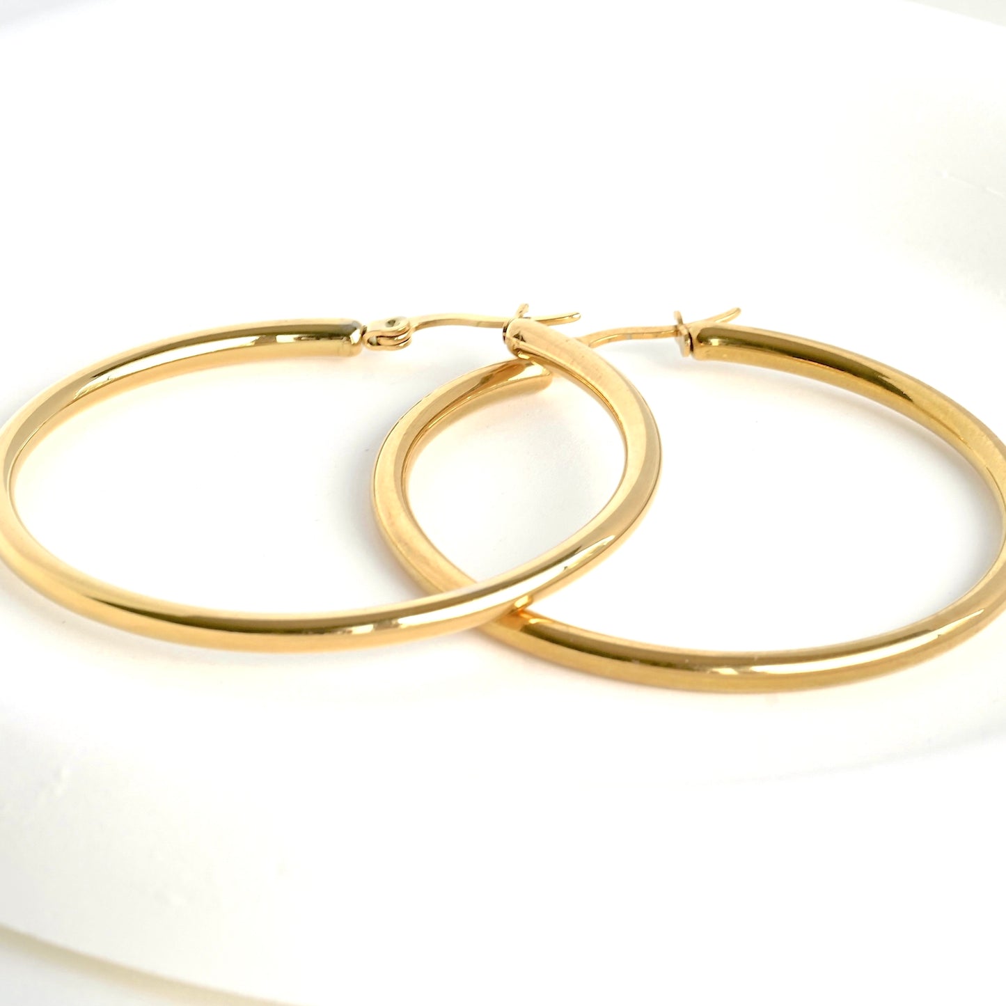 close-up view of a pair of bold hoop earrings on a white background