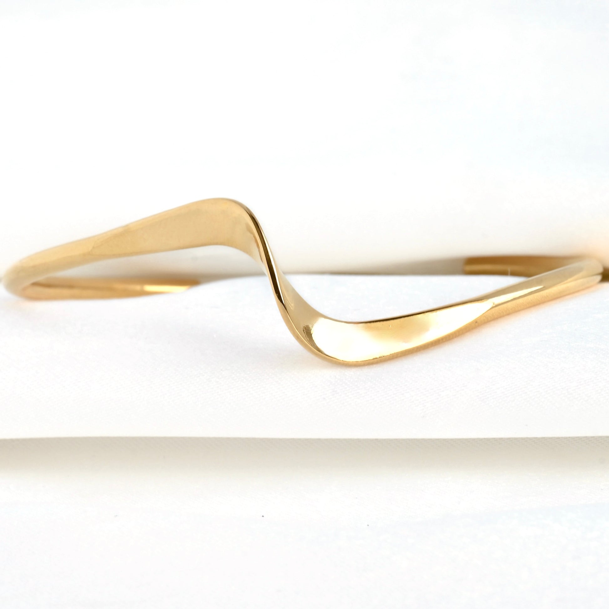 Front close up view of the wave shape in the front of the gold cuff bracelet