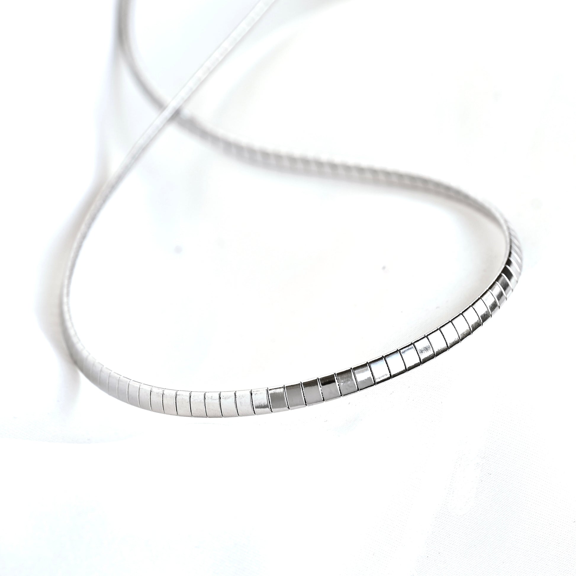 A silver snake chain necklace with a polished rectangular link accent, displayed on a clean white background.