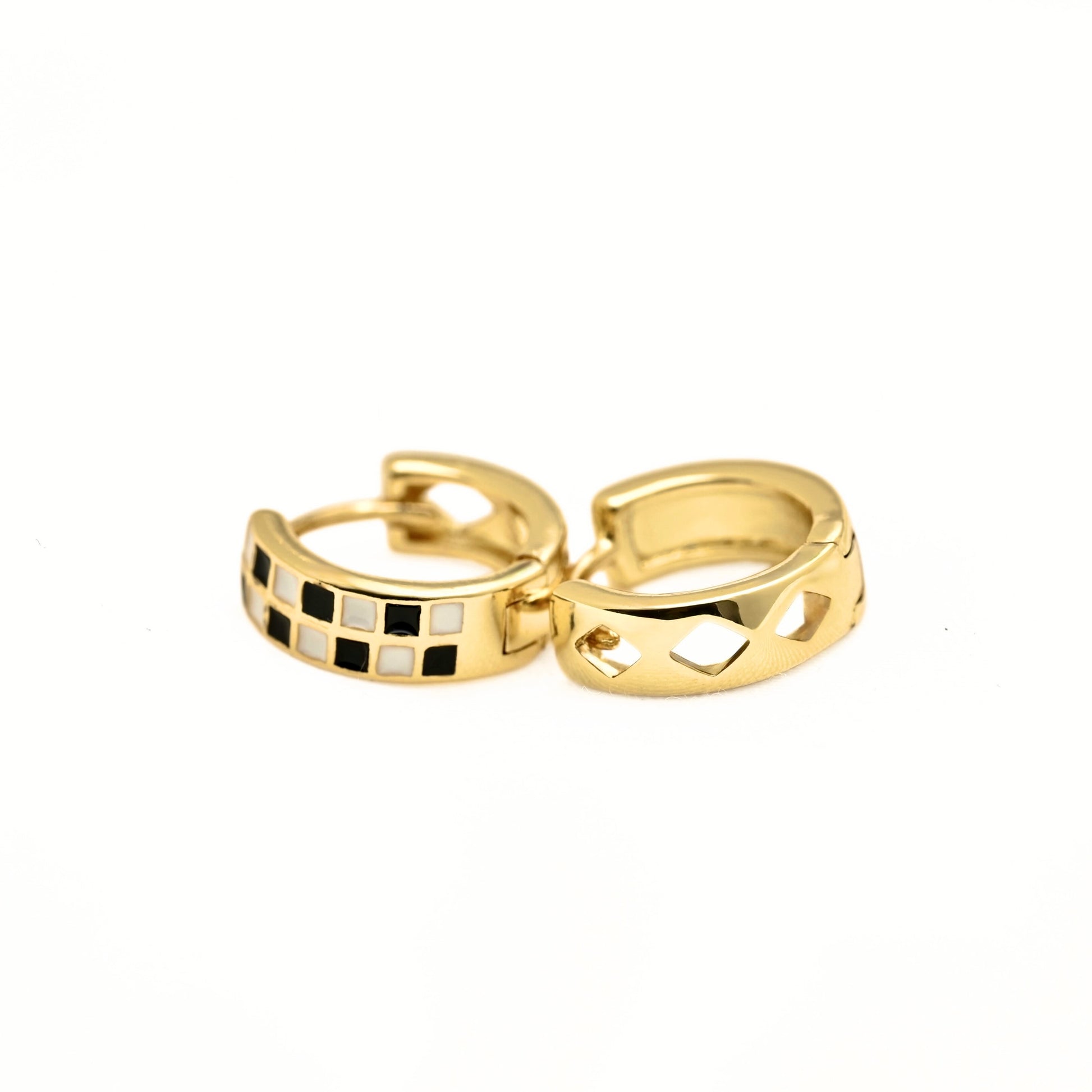 A pair of gold huggie hoop earrings on a plain white background. One earring features a checkered pattern of gold, black, and white square inlays, while the other shows the back side with a polished gold geometric cutout design.