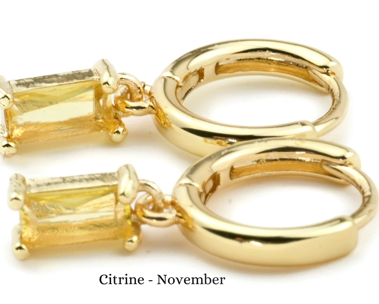 Gold hoop earrings with citrine stones on a white background