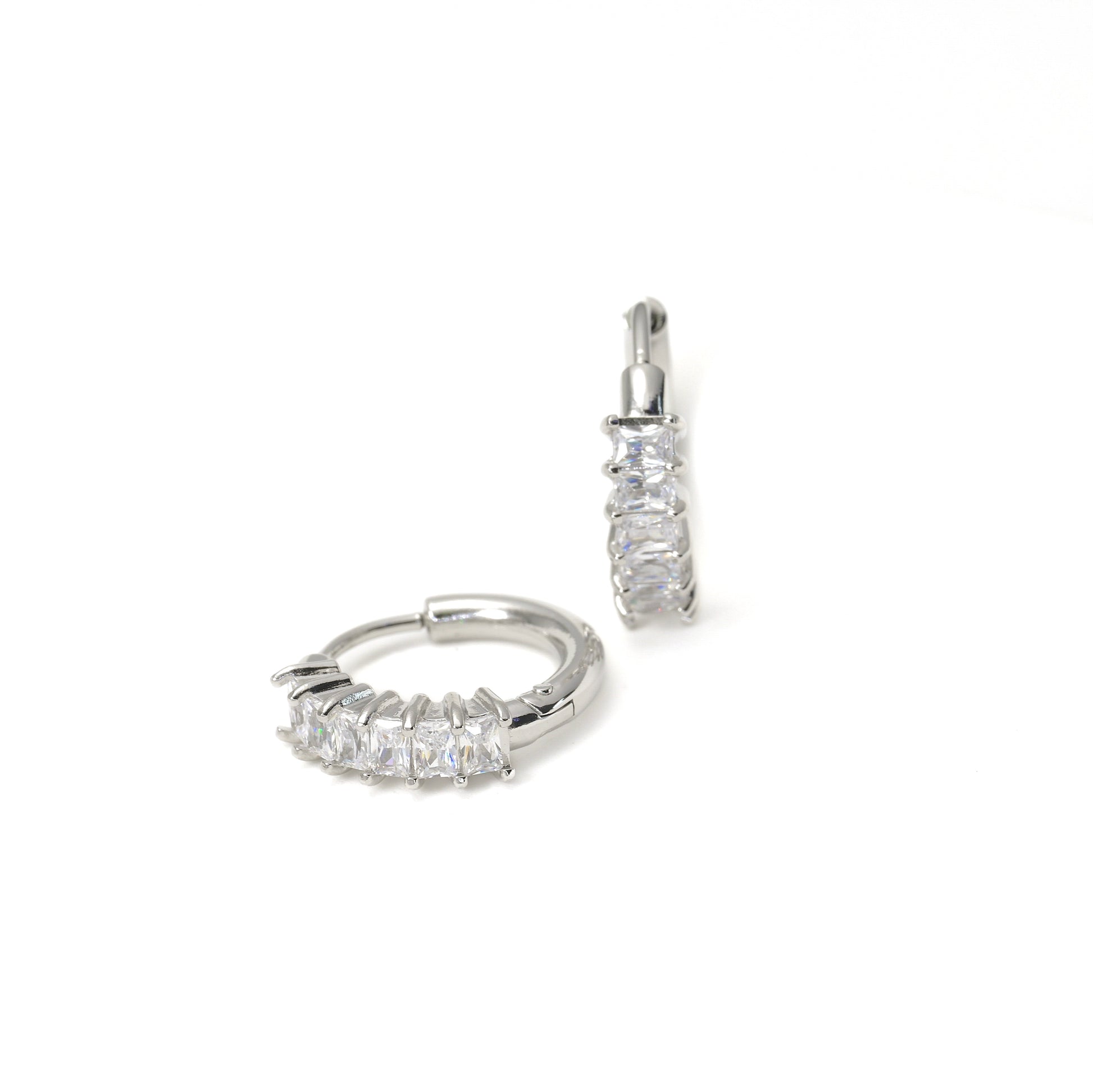 Pair of silver hoop earrings with clear baguette cut cubic zircnonia on a white background