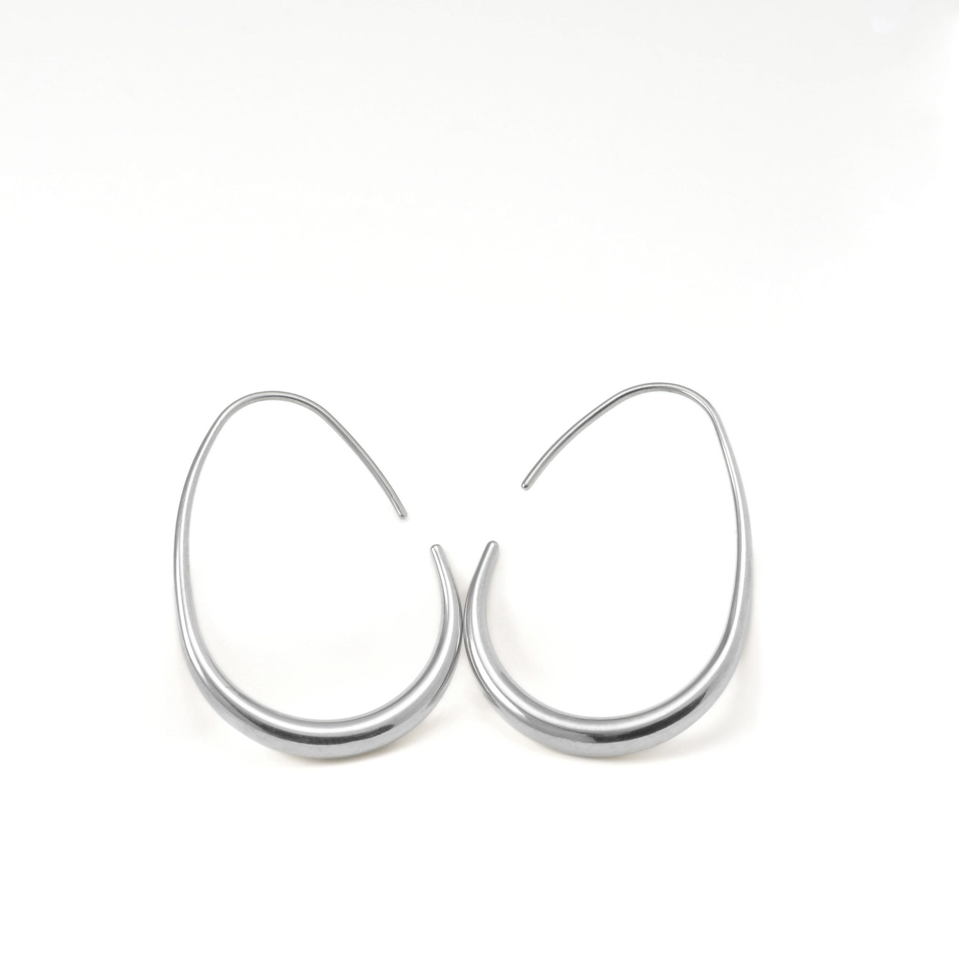Pair of large silver hoop earrings with a hook clasp on a white background