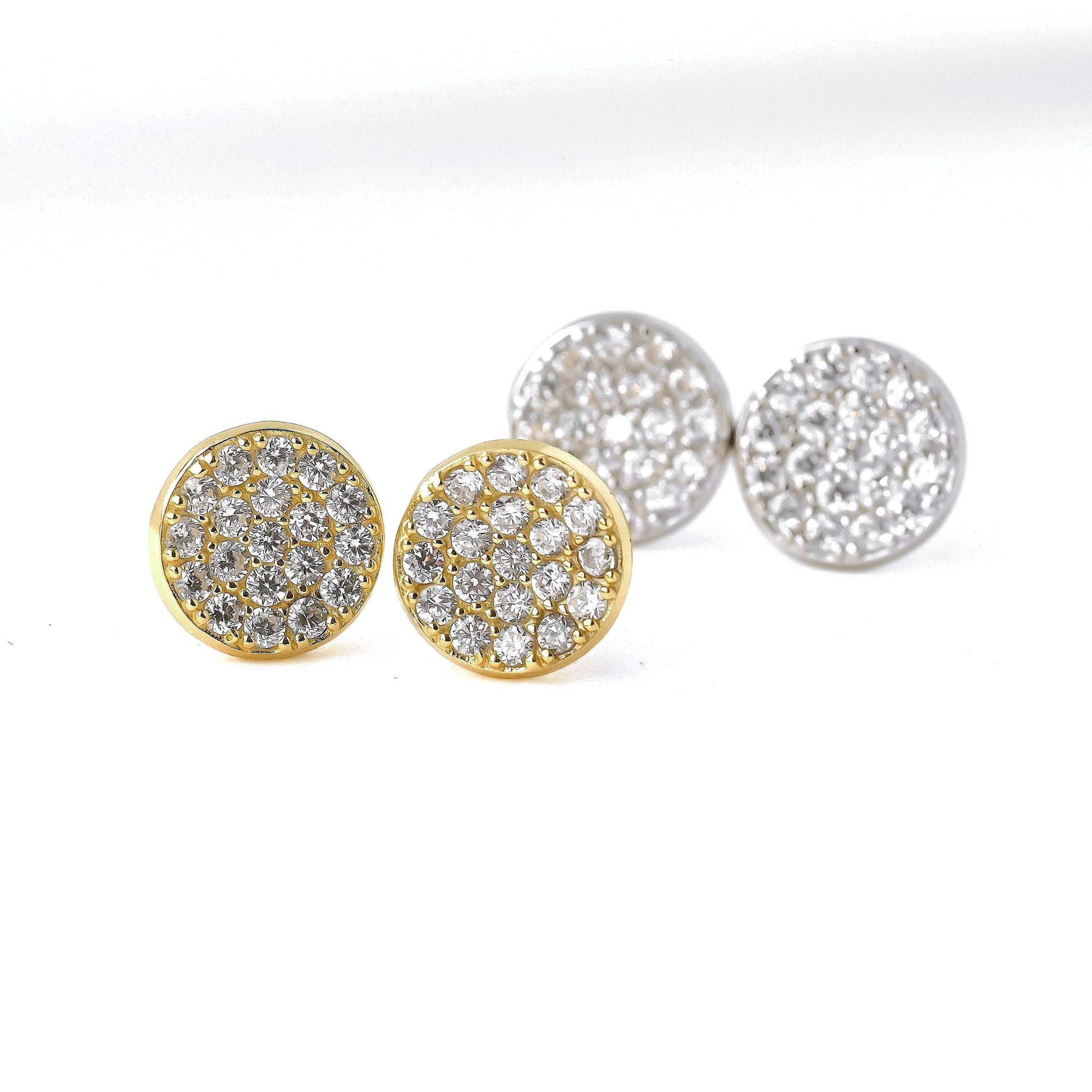 Pair of gold and silver circle earrings with CZ stones on a white background