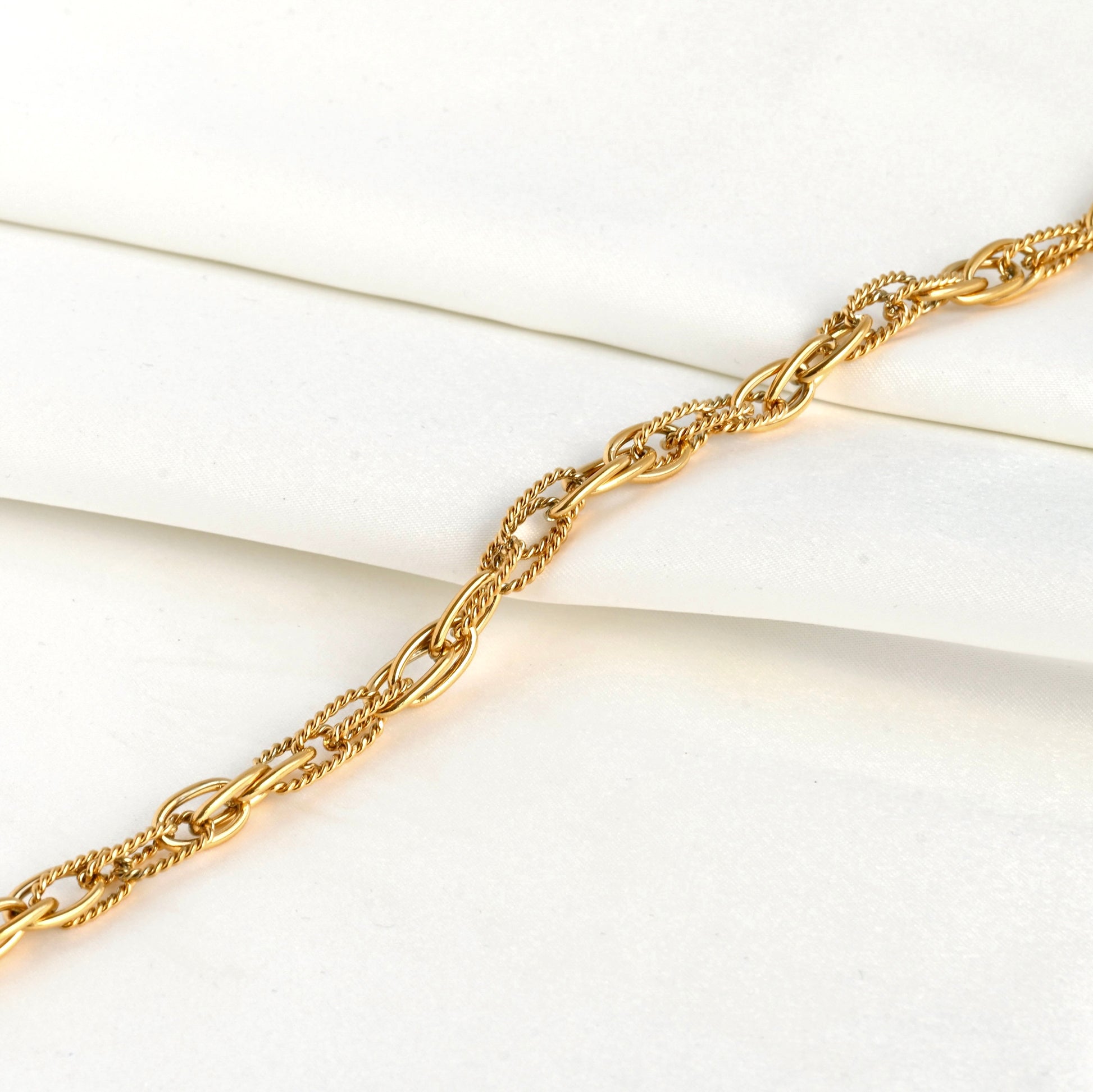 Gold mixed oval link chain on a white background