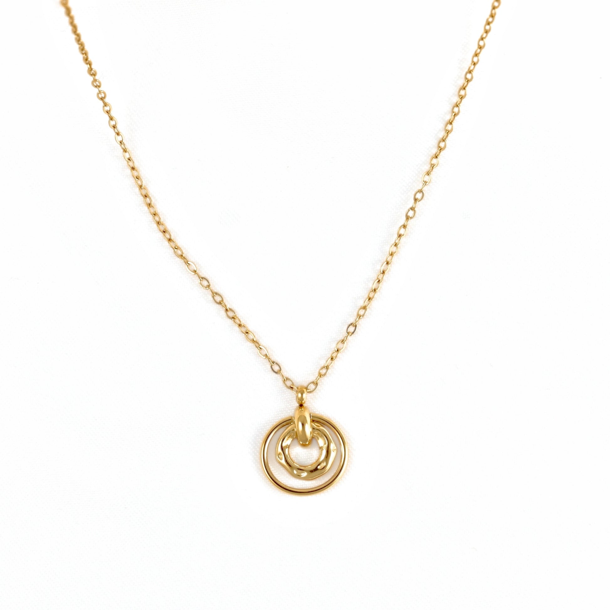A delicate gold chain necklace featuring a pendant with two interlocking circular rings, one of which has a small heart-shaped cutout, shown against a plain white background.