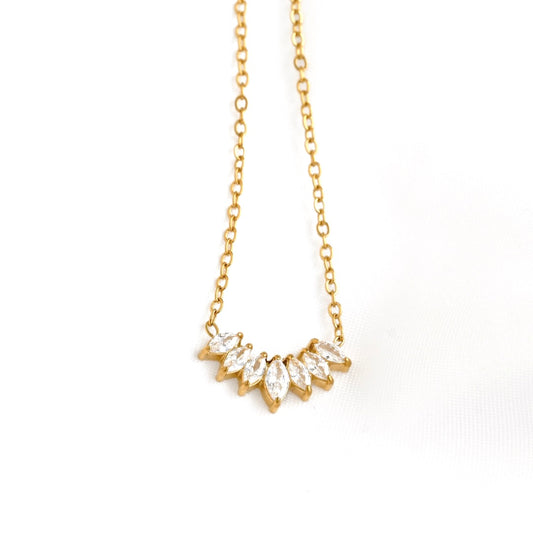 A delicate gold chain necklace featuring a small, curved cluster of marquise-cut clear crystals in a gold setting, displayed against a clean white background.