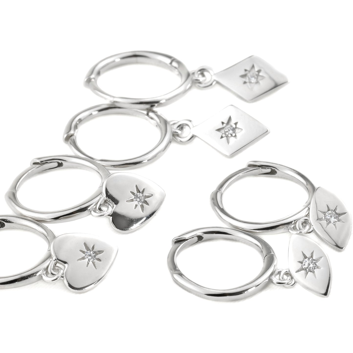 Set of silver charm hoop earrings with heart, evil eye and star charms on a white background