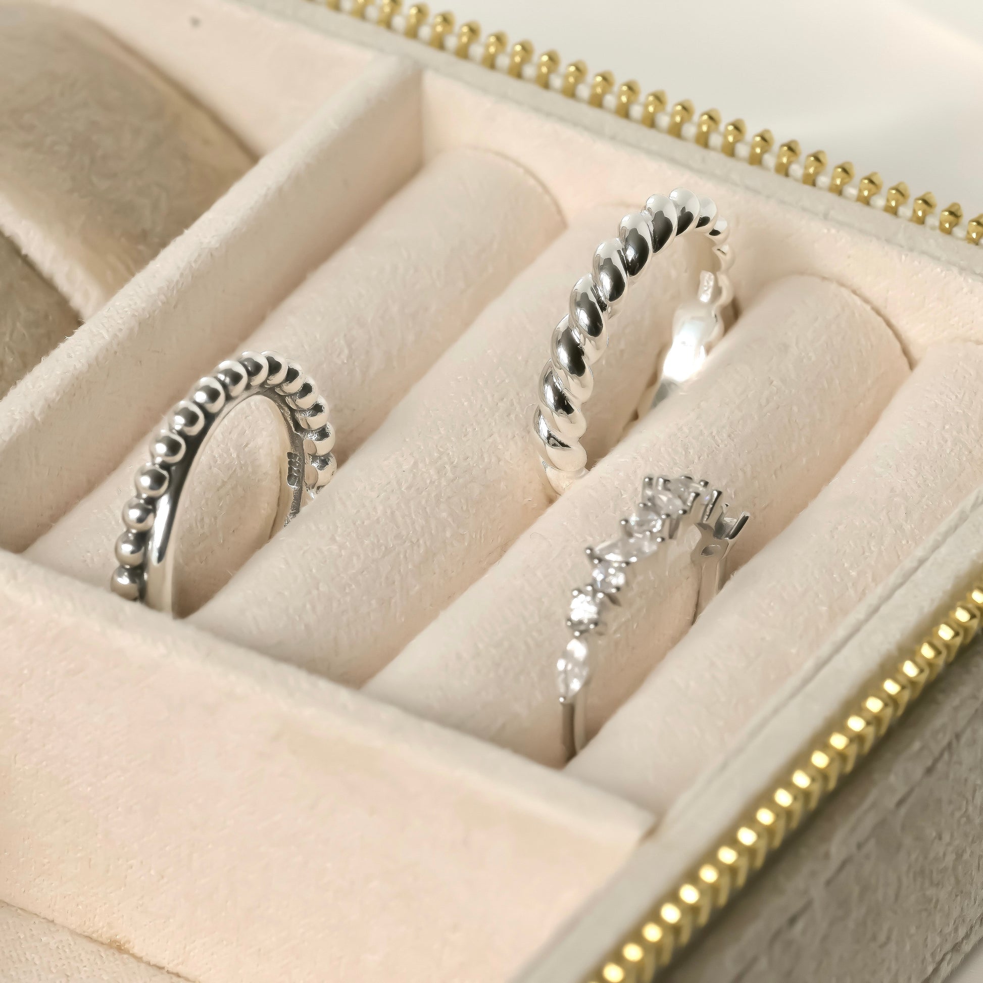 Silver rings in a jewelry box with gold accents