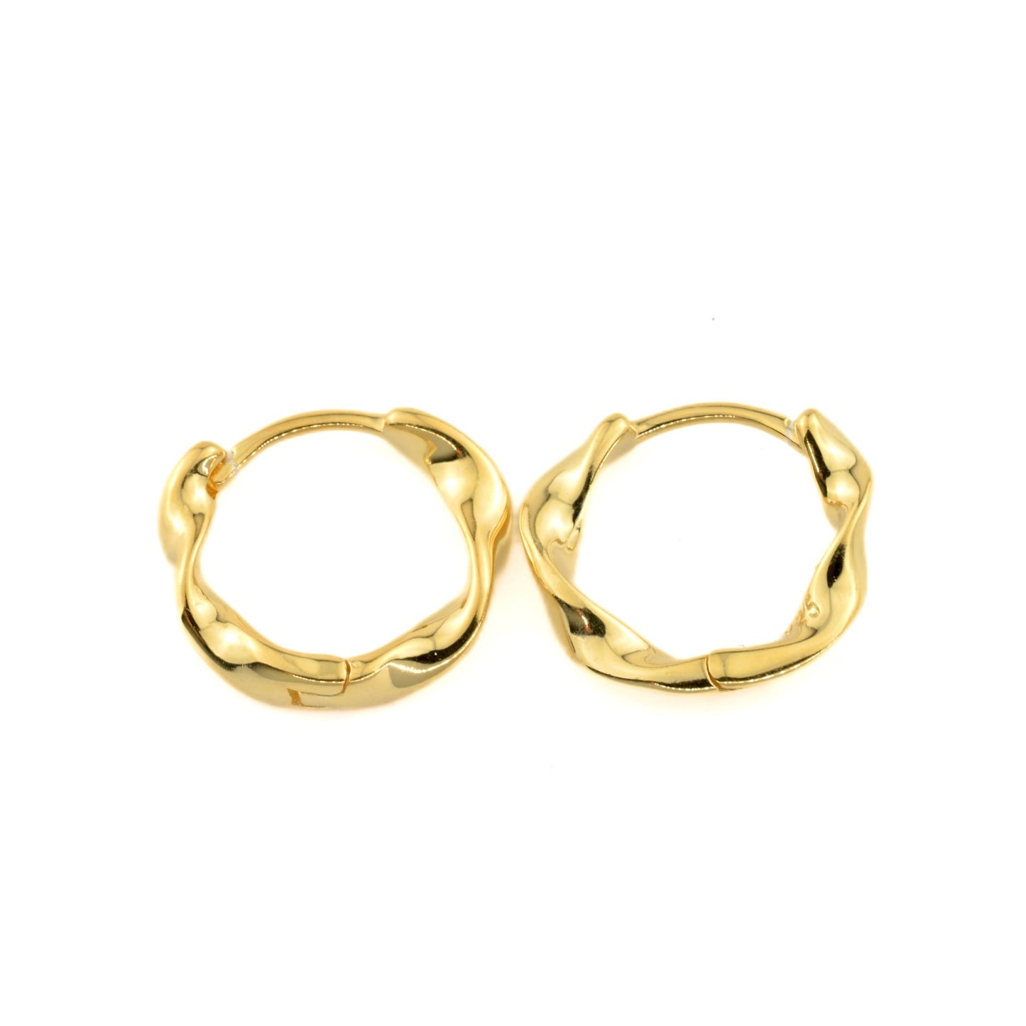 Top view of twisted gold huggie hoop earrings on a white background