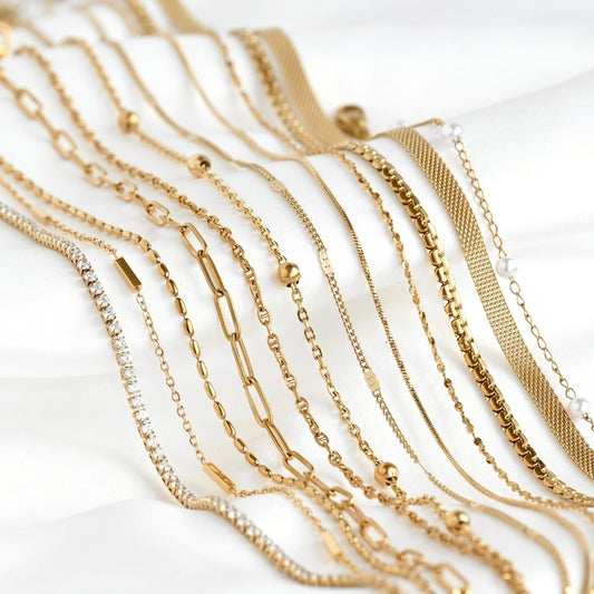 Collection of gold chain necklaces on a white background