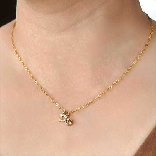 Gold singapore necklace with a letter 'D' pendant  and november birthstone on a person.