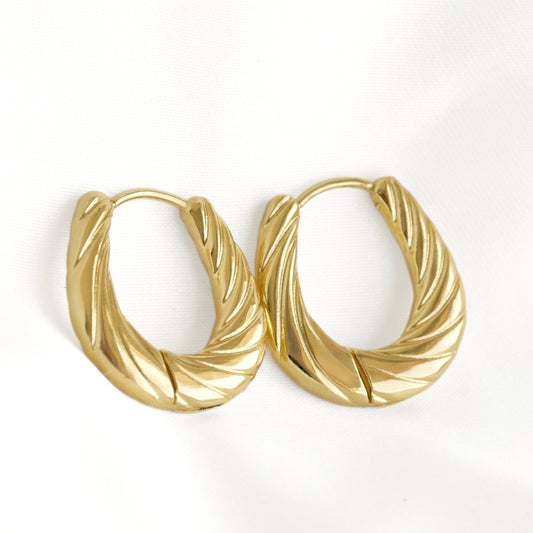 A pair of gold-toned twisted hoop earrings with a textured, ribbed surface, displayed on a clean white background.