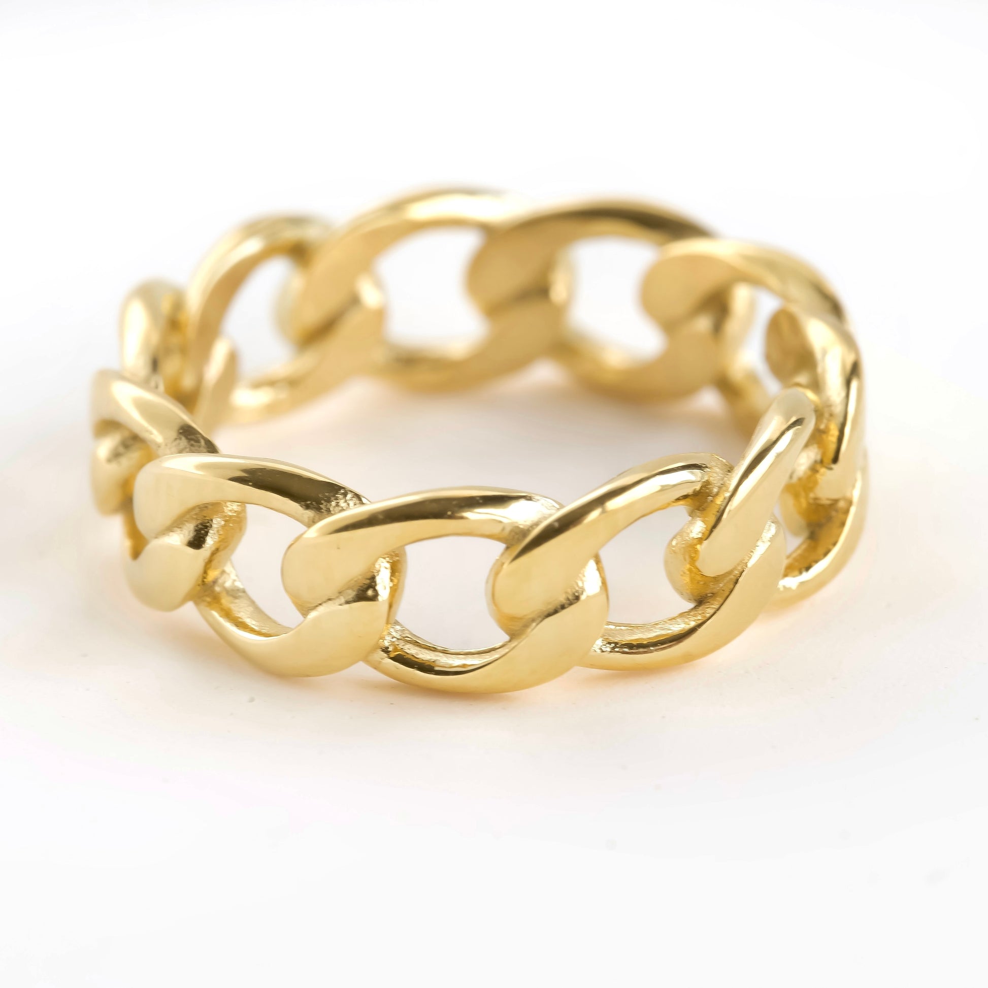 Gold curb link chain ring on a white background