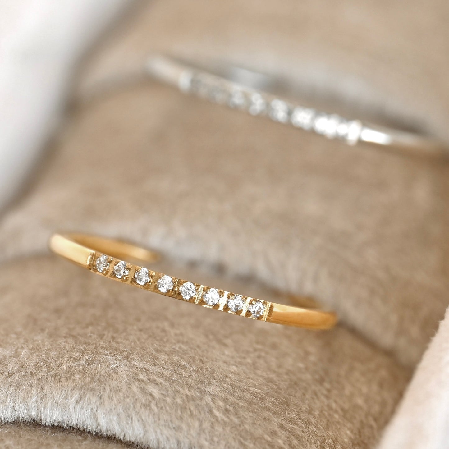 Gold and silver slim cz rings on a soft fabric background