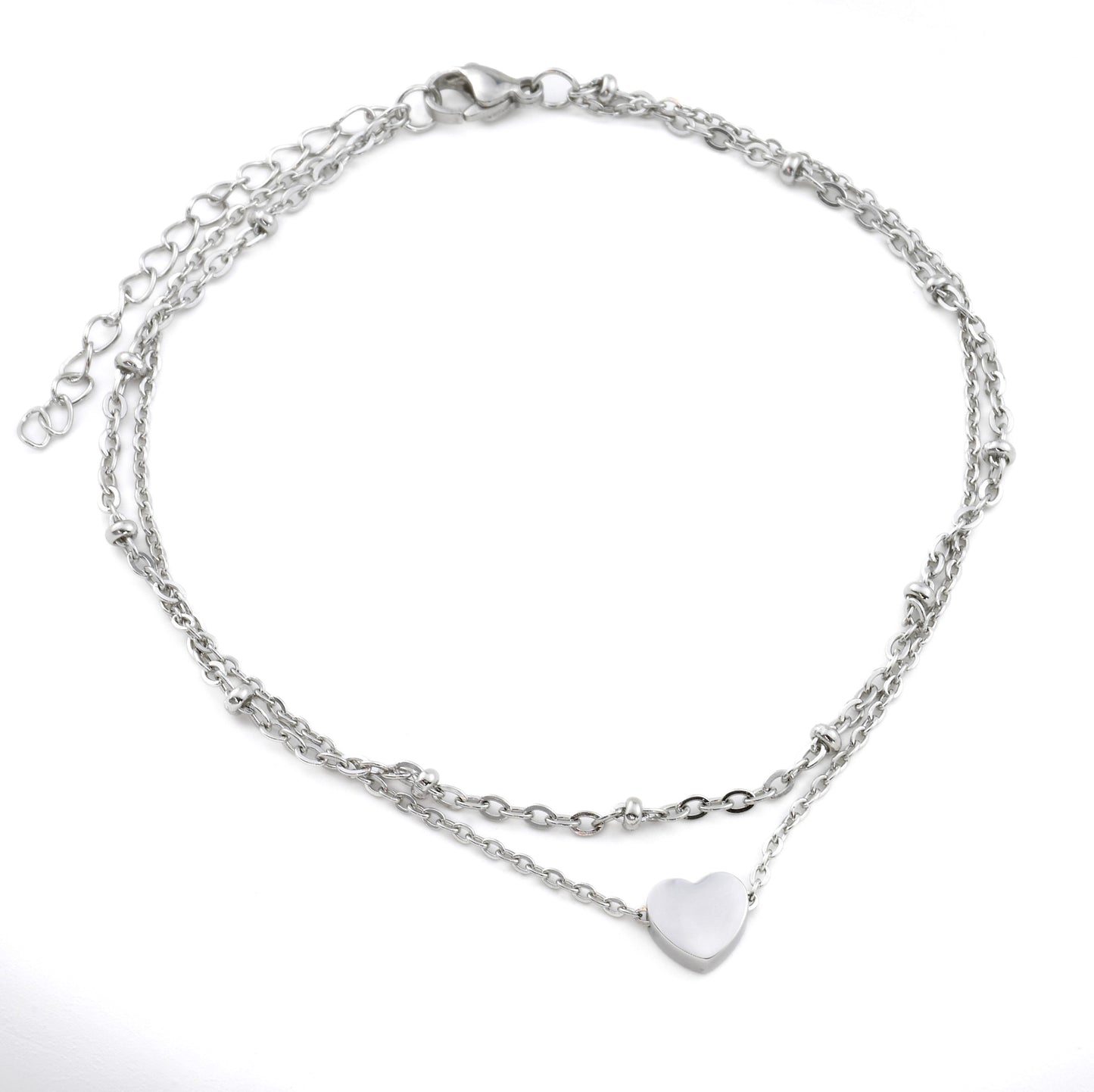 Silver chain anklet with a heart charm on a white background