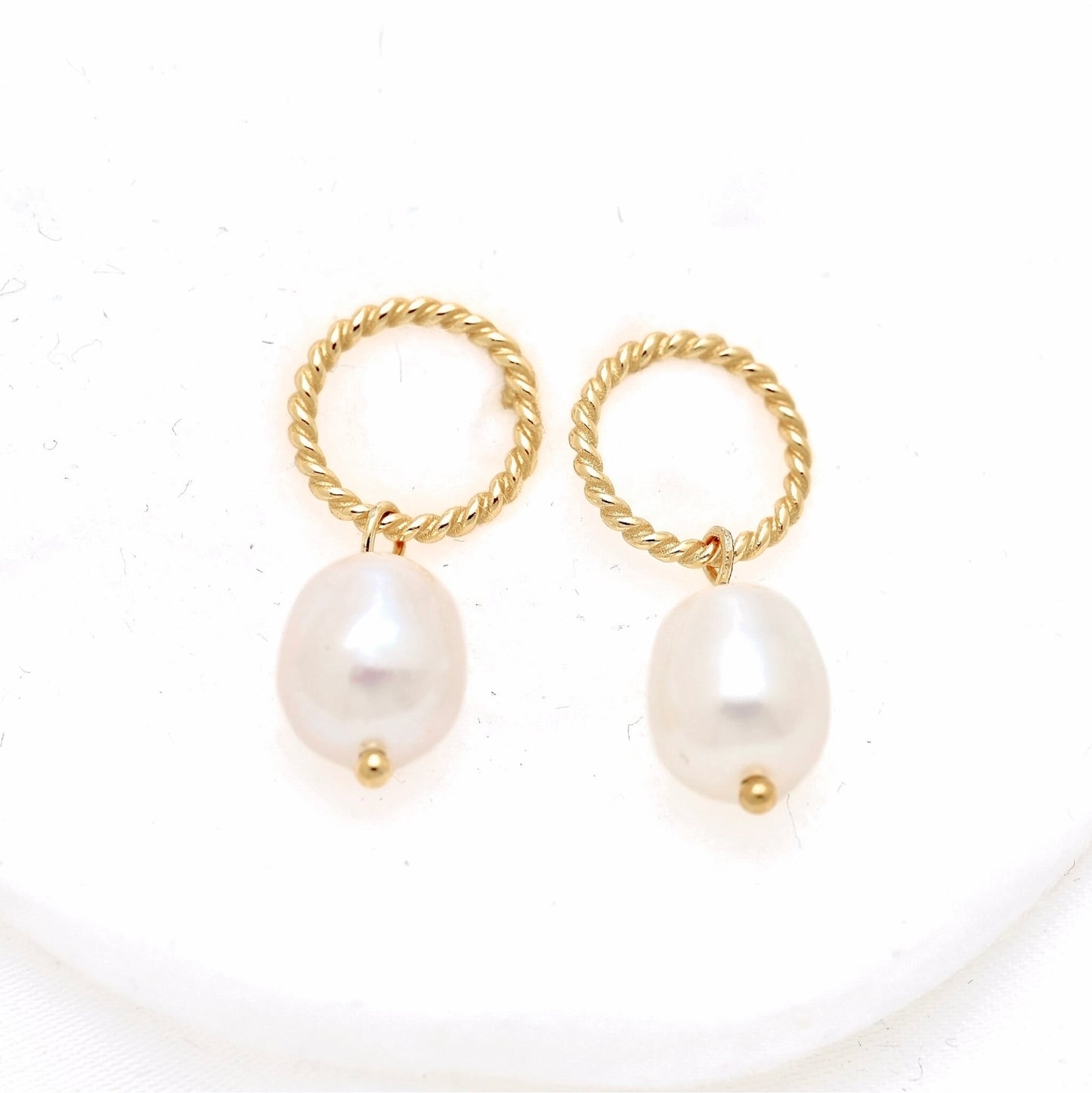A pair of gold hoop earrings with twisted rope tops and dangling baroque pearl drops, displayed on a clean white background.