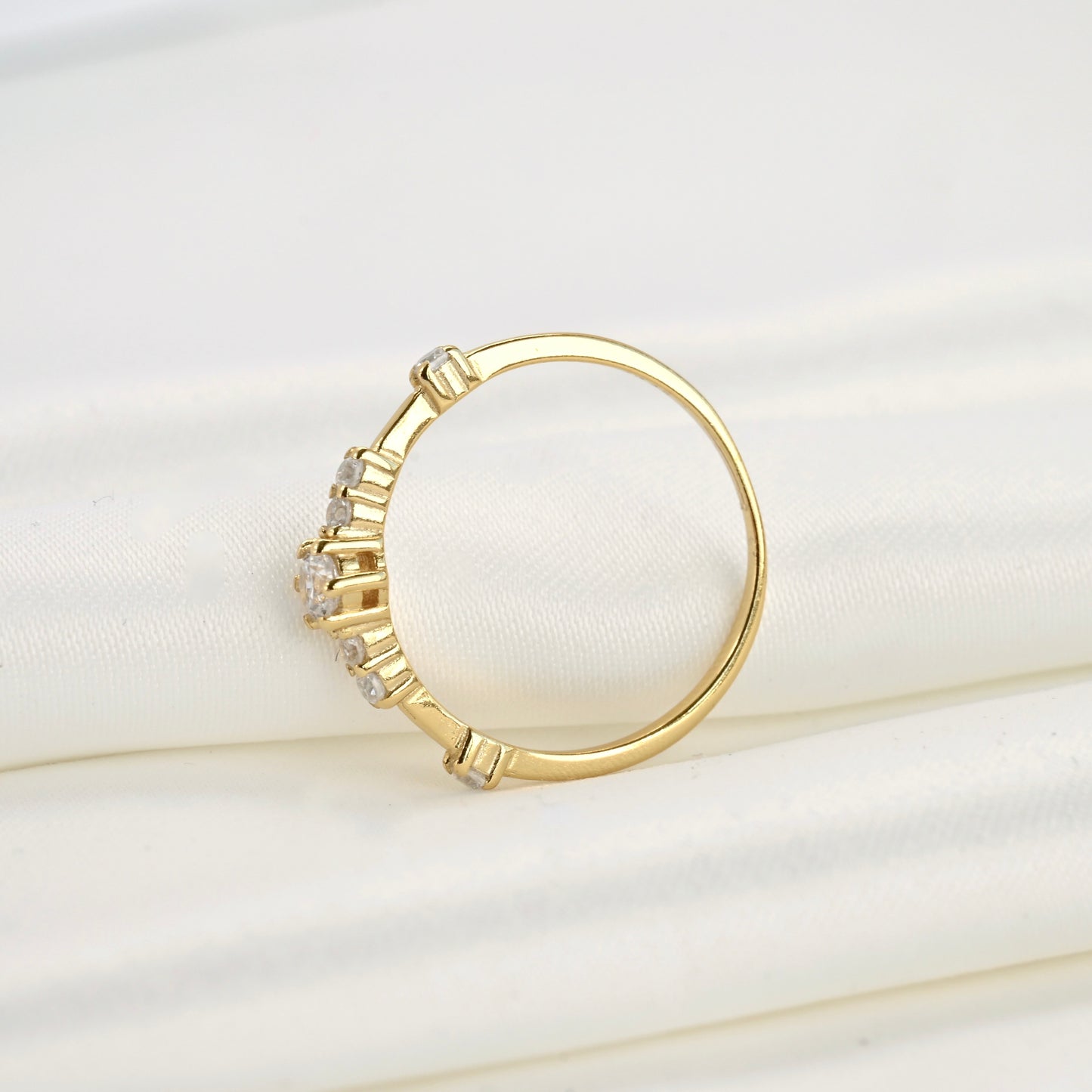 Gold ring with diamonds on a white cushion