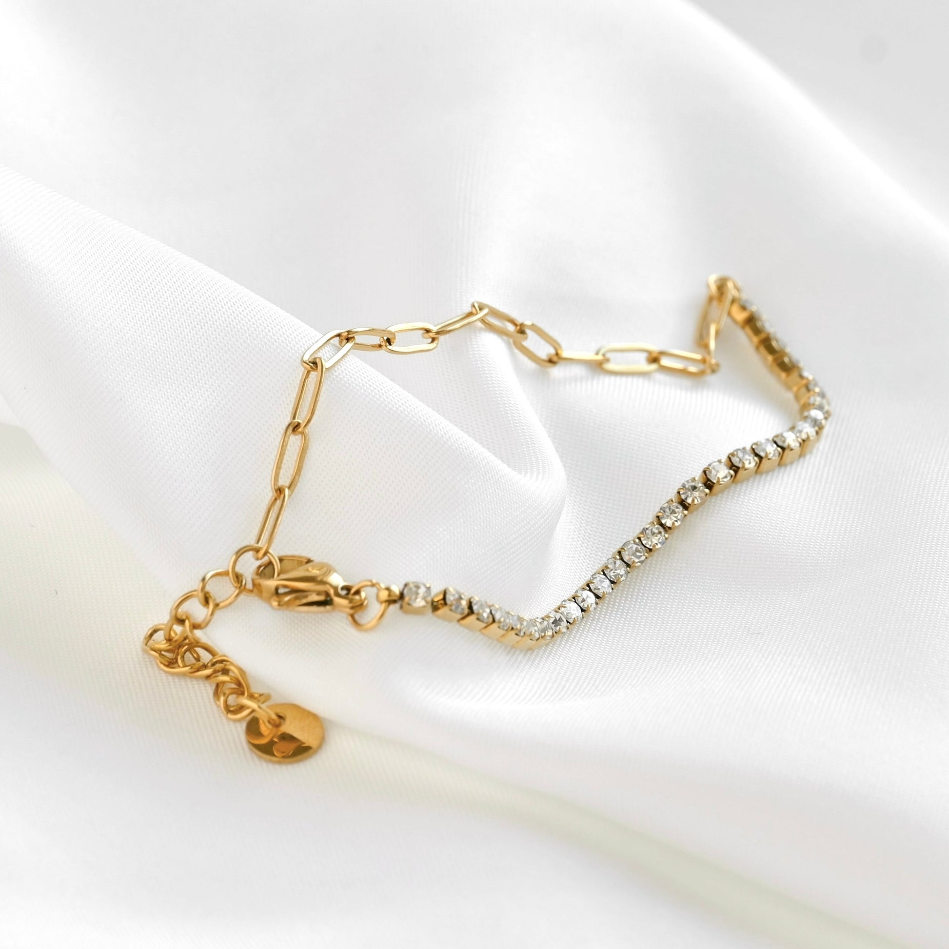 paperclip and tennis mixed chain bracelet with lobster claw clasp and extender on a white fabric background
